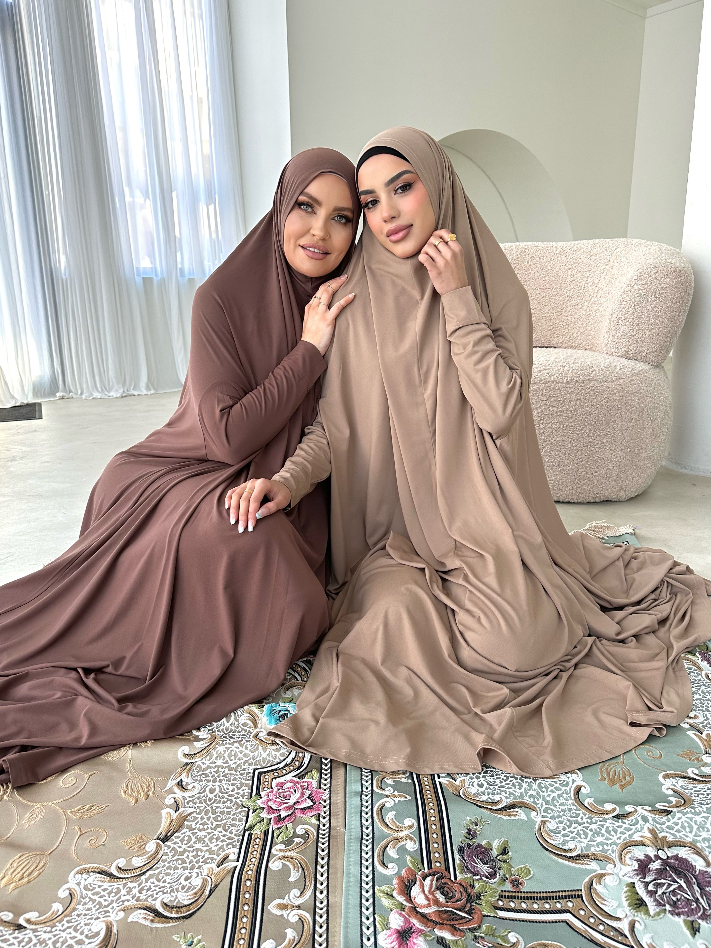Models are wearing a floor-length jilbab with a loose, flowing silhouette, styled for comfortable and modest everyday wear.