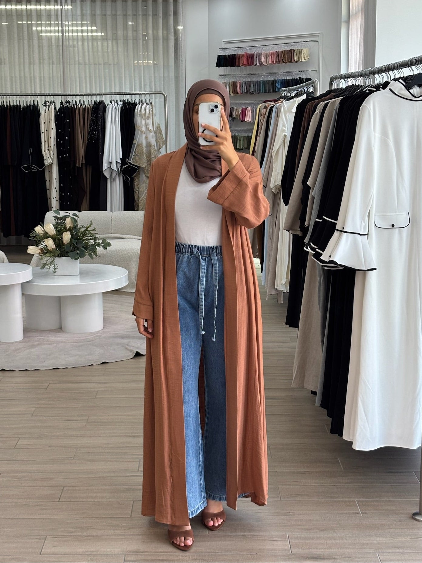 Woman wearing a long lightweight open kimono in orange, featuring a flowing longline silhouette and relaxed fit.