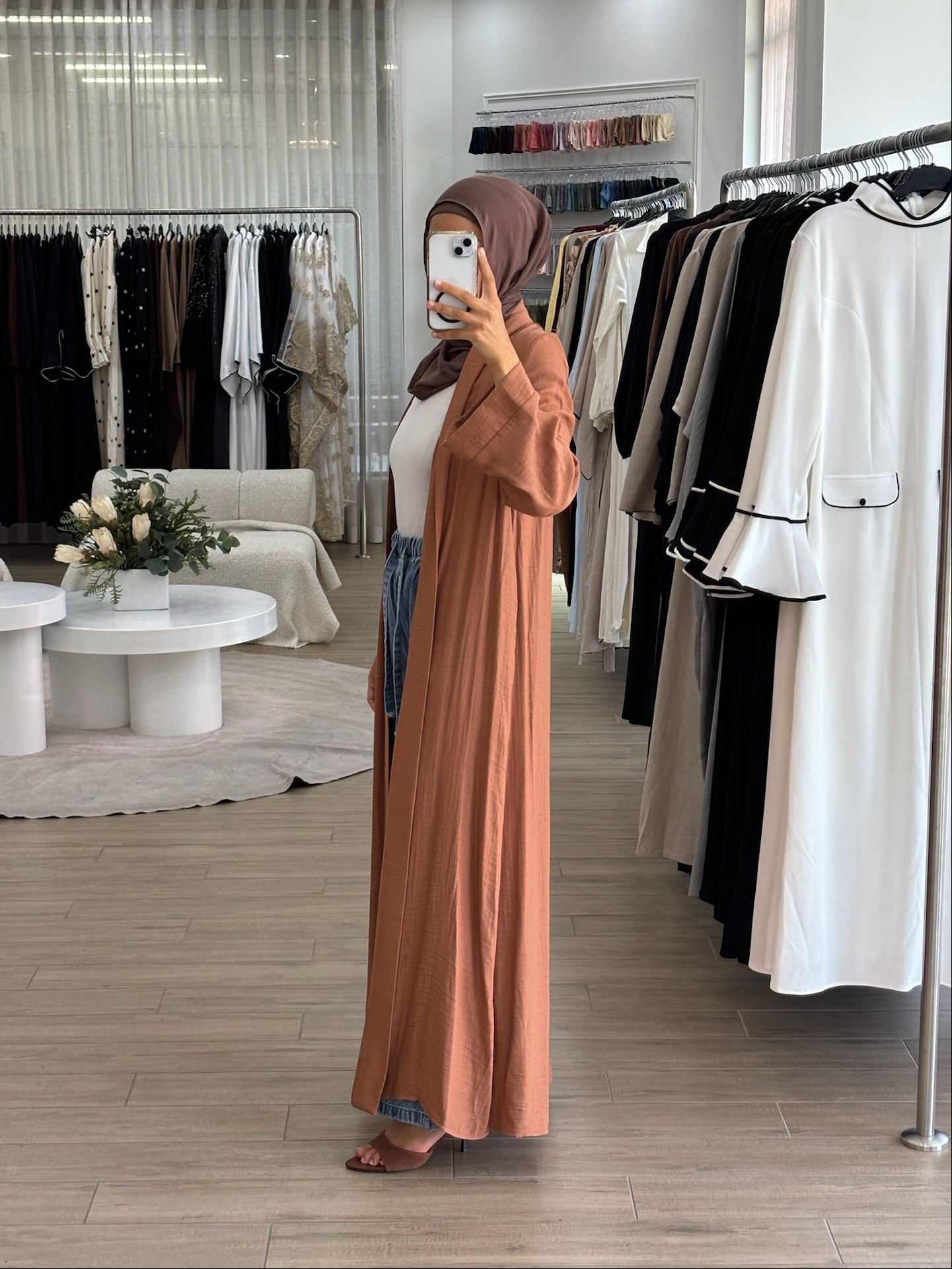 Side view of a long light kimono in orange, showing its airy fabric and fluid drape.