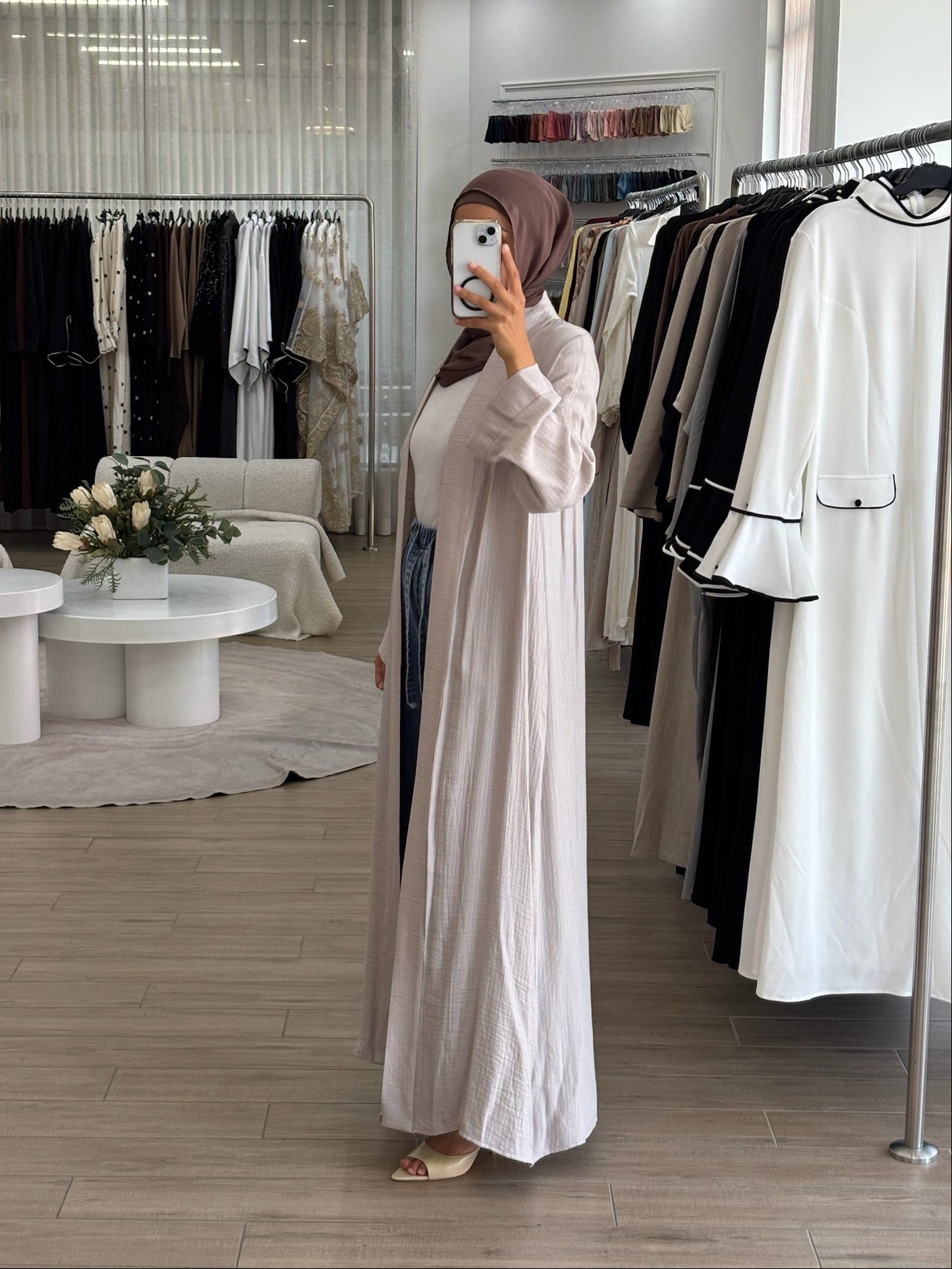 Side view of a long light kimono in stone, showing its airy fabric and fluid drape.