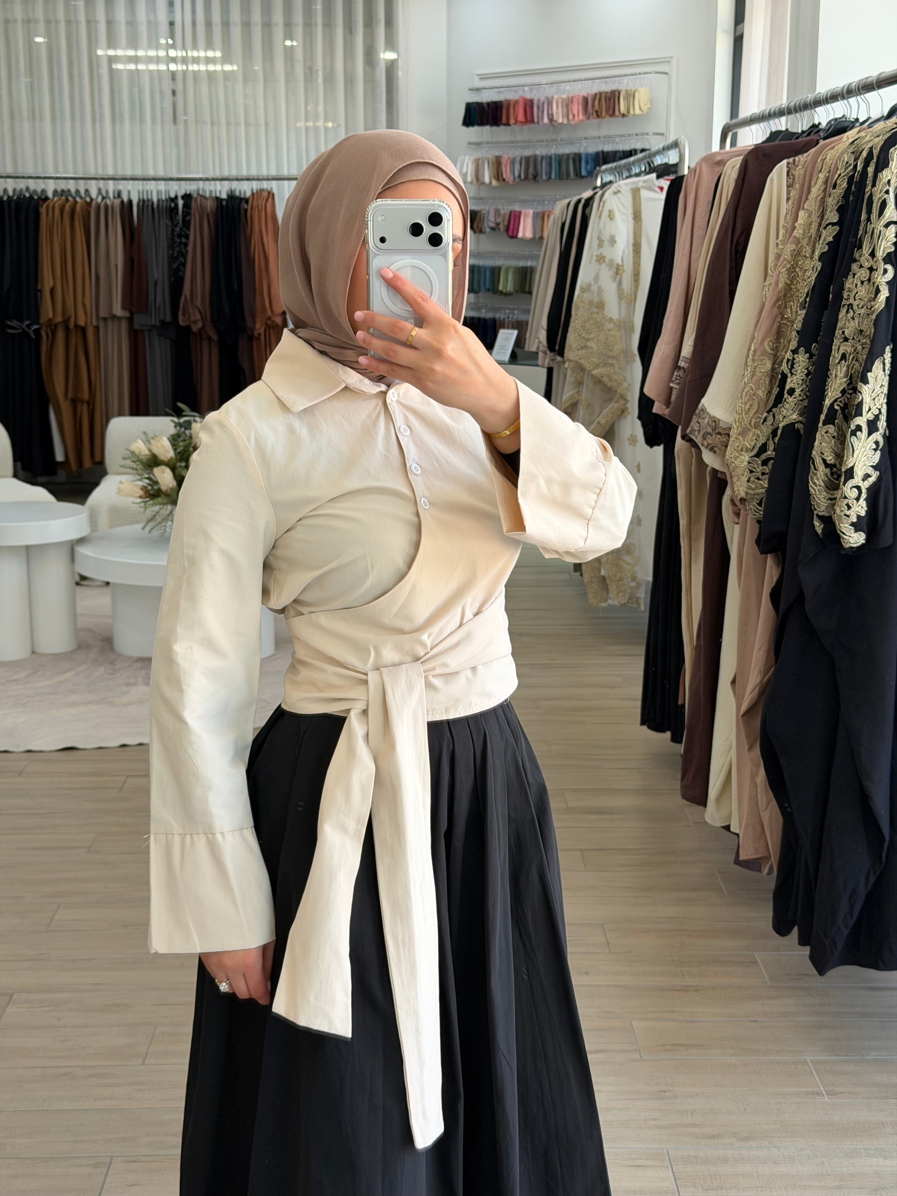 Close-up of the tailored collar and button-down front on a beige wrap shirt.