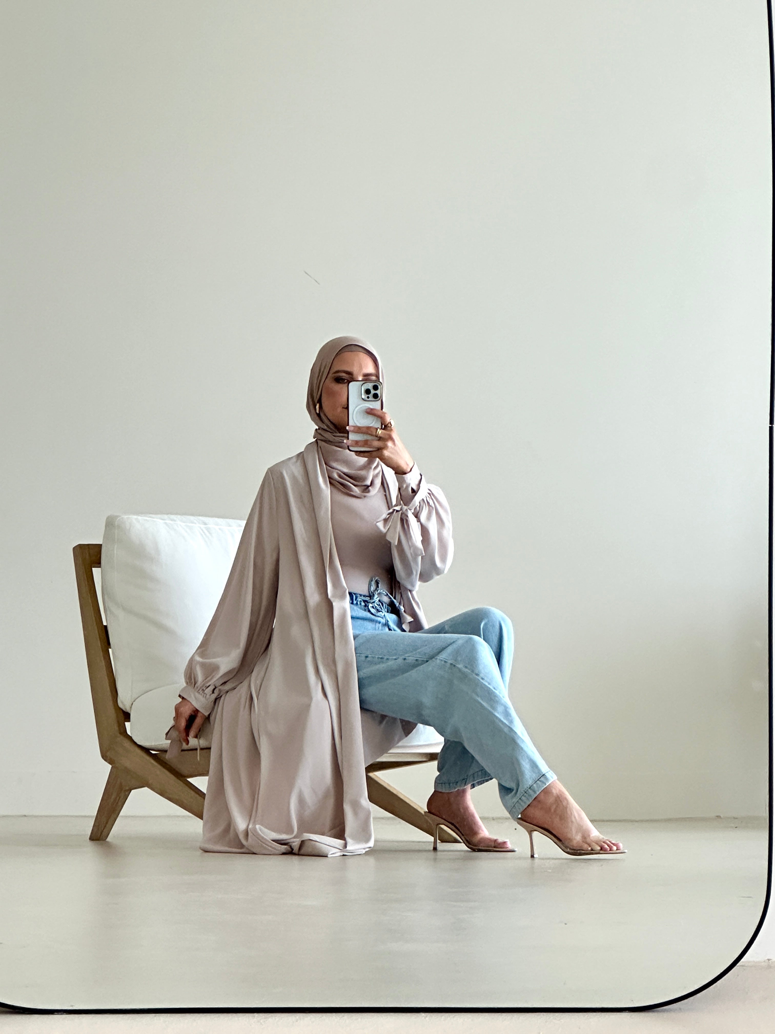 Model wearing mid blue straight-flow denim pants styled modestly with a long cardigan, showcasing the wide-leg and relaxed fit.