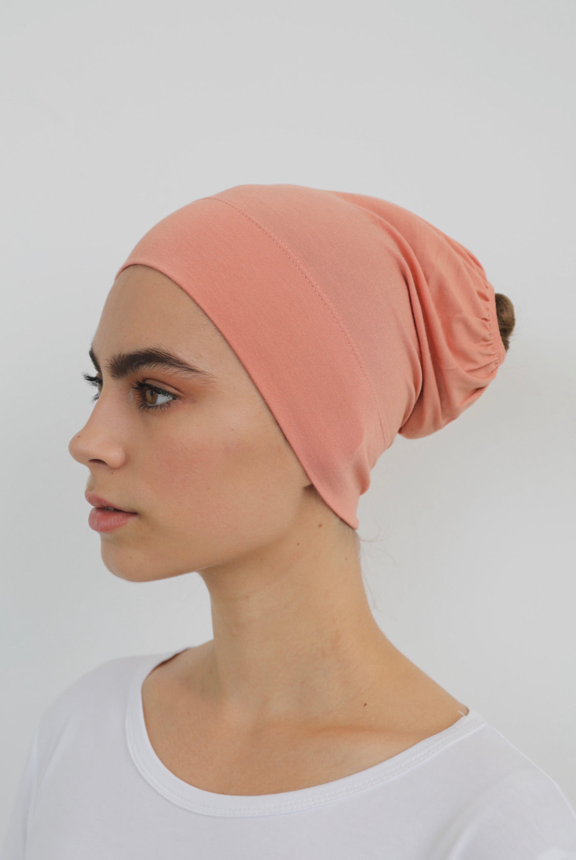 Bamboo under-scarf cap designed to cover hair beneath a hijab, made from soft, breathable natural bamboo fibers with cotton spandex stretch for comfort. Partially closed at the back with an elastic edge to comfortably accommodate hair.