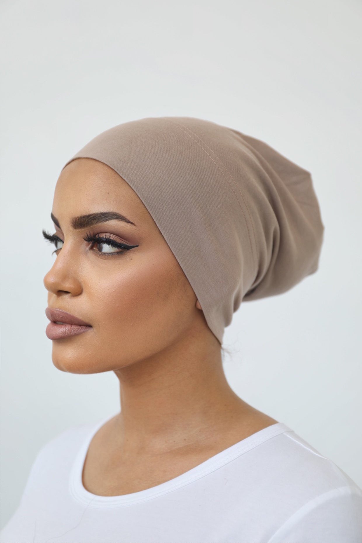 Model wearing a closed under-scarf cap (Veil of Faith) designed to cover hair under a scarf, made from soft natural fibres with a cotton-spandex blend for a comfortable, non-slip fit suitable for all-day wear.