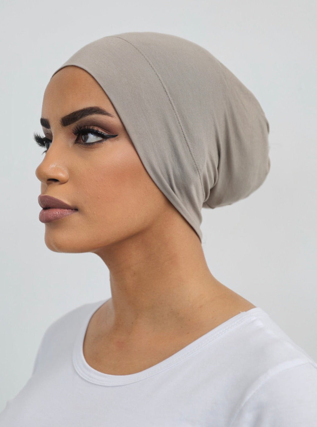 Bamboo under-scarf cap designed to cover hair beneath a hijab, made from soft, breathable natural bamboo fibers with cotton spandex stretch for comfort. Partially closed at the back with an elastic edge to comfortably accommodate hair.
