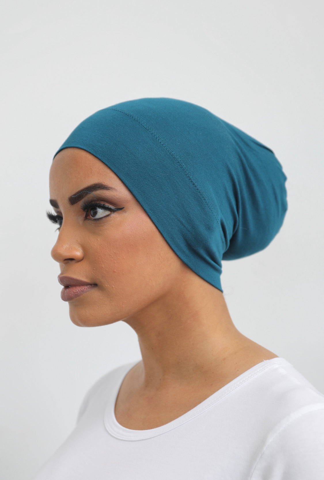 Bamboo under-scarf cap designed to cover hair beneath a hijab, made from soft, breathable natural bamboo fibers with cotton spandex stretch for comfort. Partially closed at the back with an elastic edge to comfortably accommodate hair.