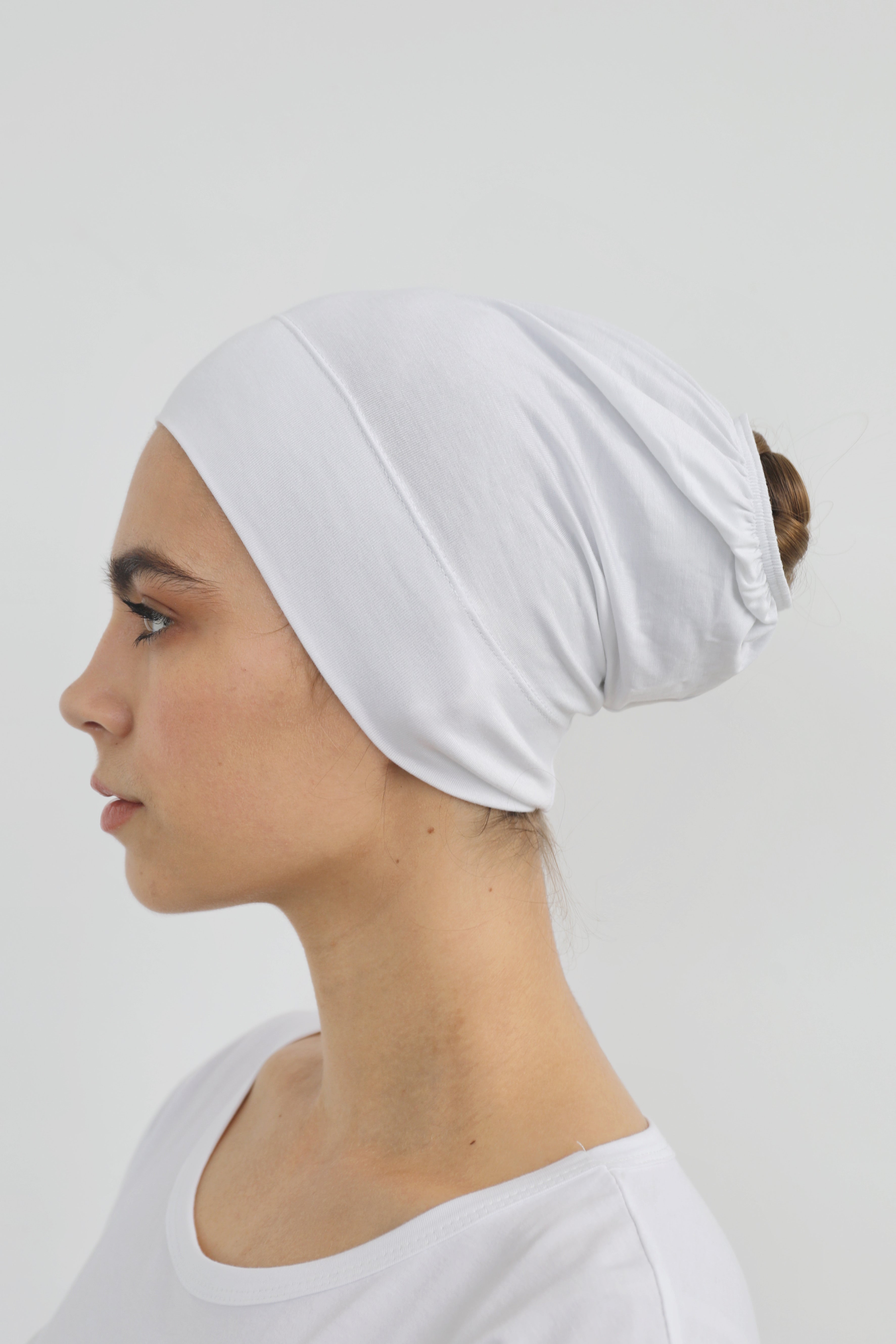 Bamboo under-scarf cap designed to cover hair beneath a hijab, made from soft, breathable natural bamboo fibers with cotton spandex stretch for comfort. Partially closed at the back with an elastic edge to comfortably accommodate hair.