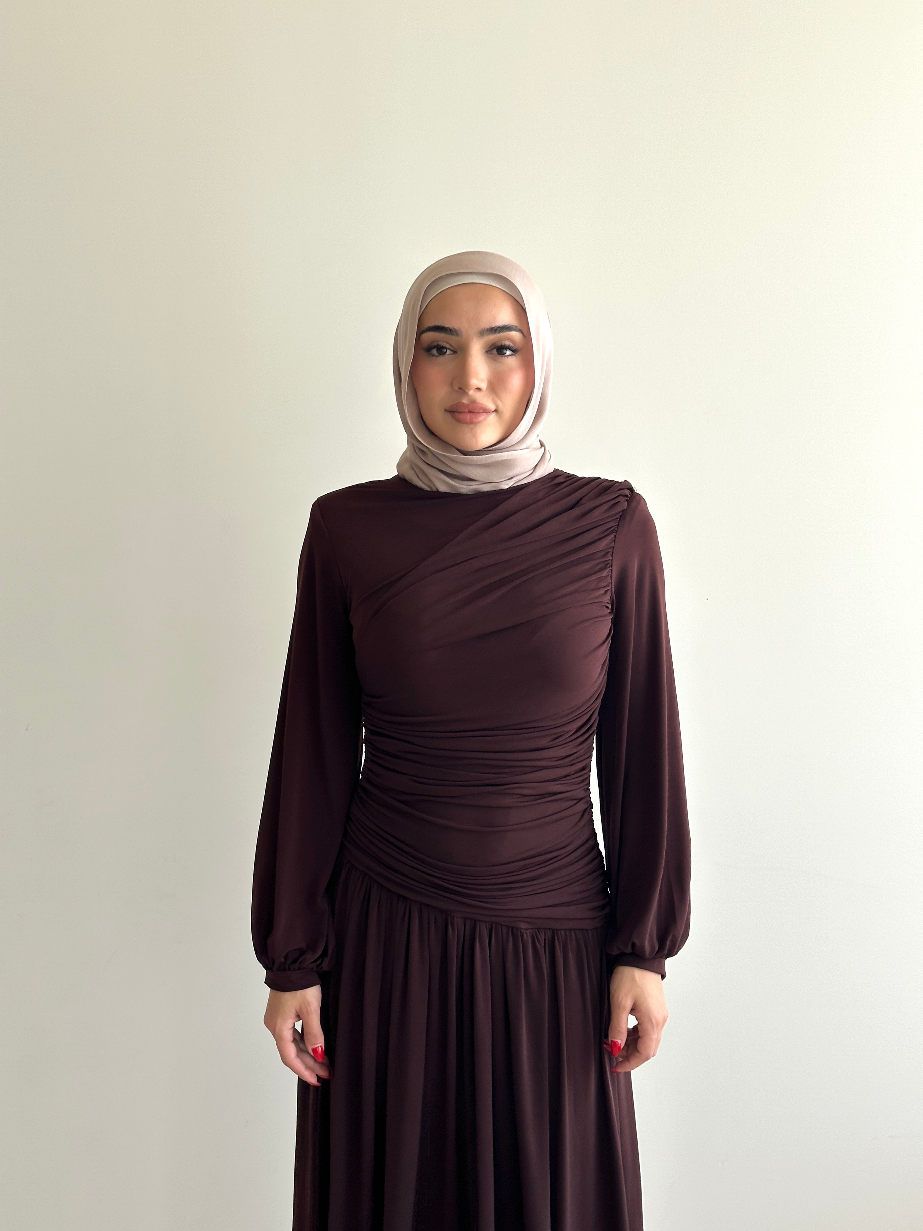 women's maxi jersey dress in brown and black. It has ruching detailing, long sleeves and is maxi for hijabis, it's modest and suitable to wear for dinner, occasions, eid, etc.