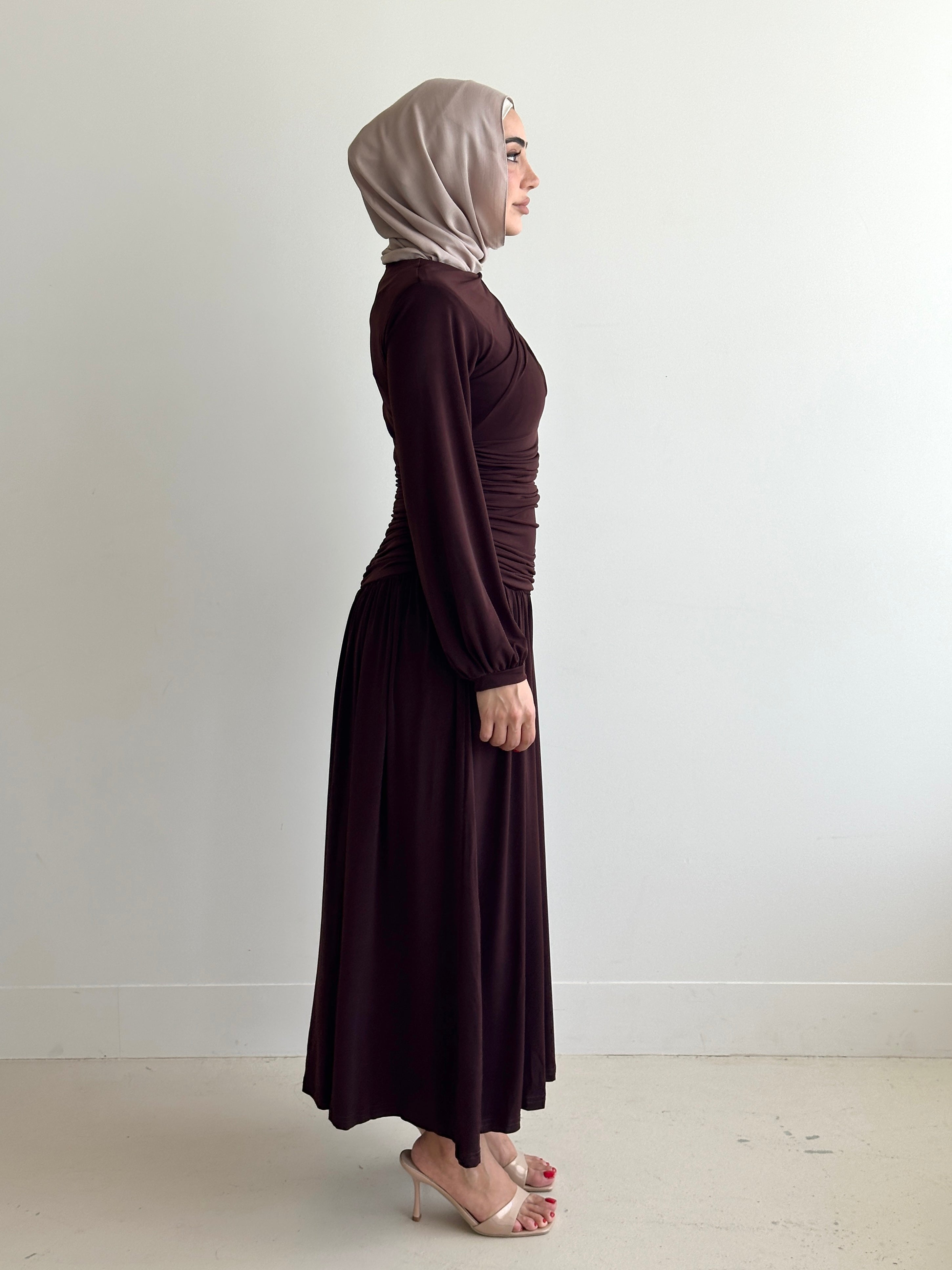 women's maxi jersey dress in brown and black. It has ruching detailing, long sleeves and is maxi for hijabis, it's modest and suitable to wear for dinner, occasions, eid, etc.