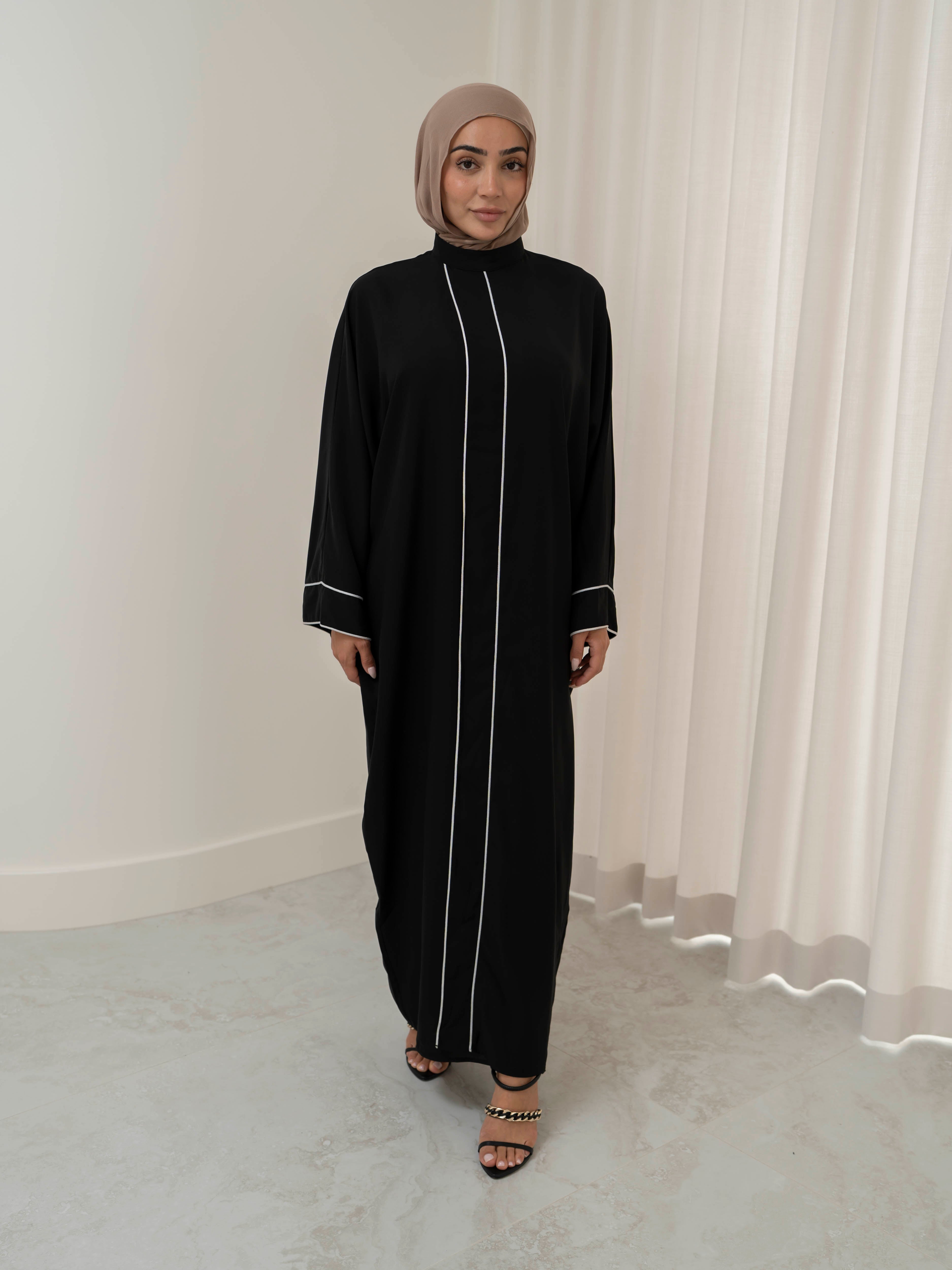 Model wearing the Noor Line abaya featuring a clean silhouette with subtle line detailing, styled for a modest and elegant look suitable for Ramadan and Eid.