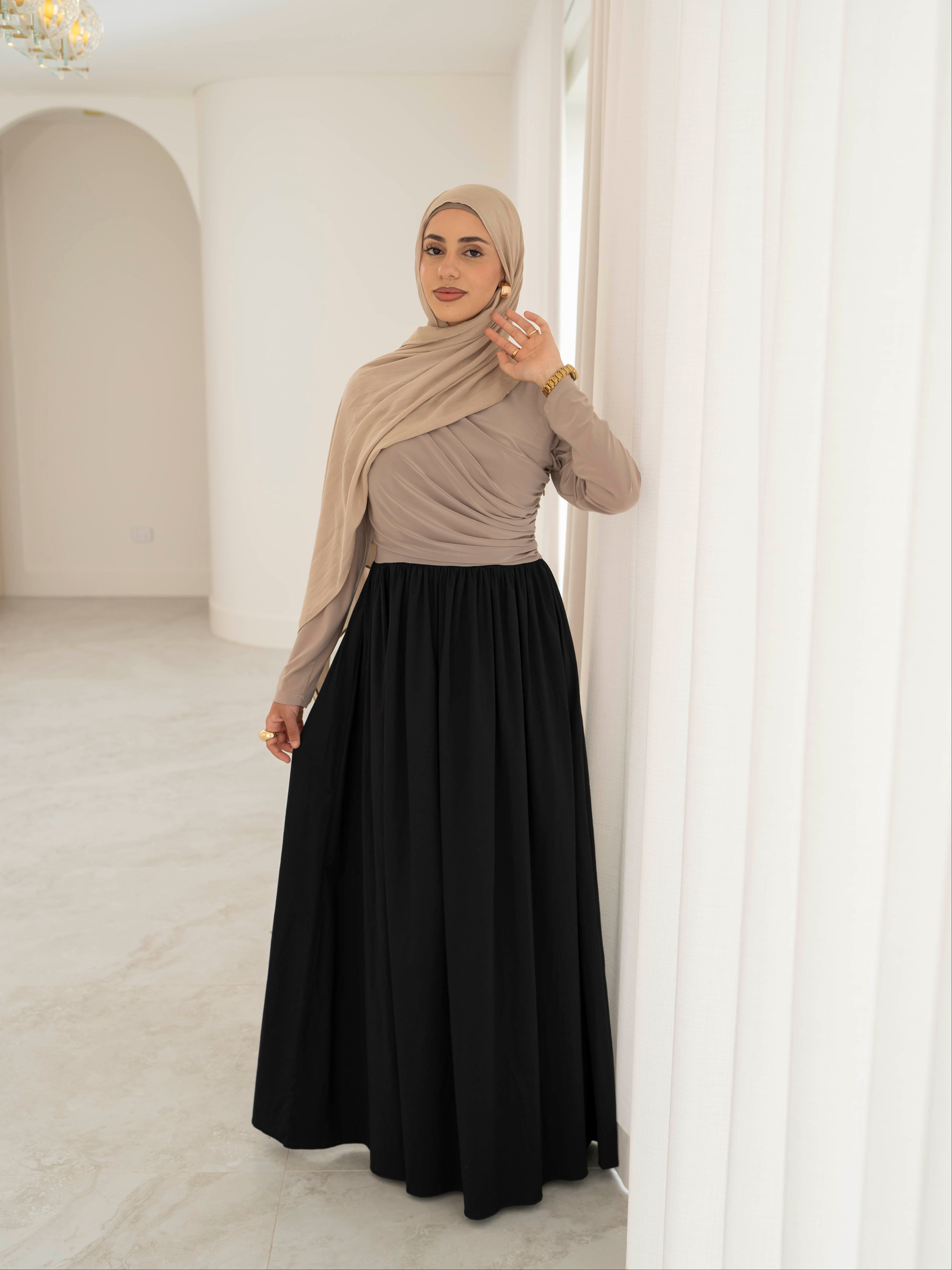 Model wearing the Aicha gathered dress featuring a jersey bodice and poplin skirt with soft gathered detailing, styled for a modest and elegant look suitable for Ramadan and Eid.