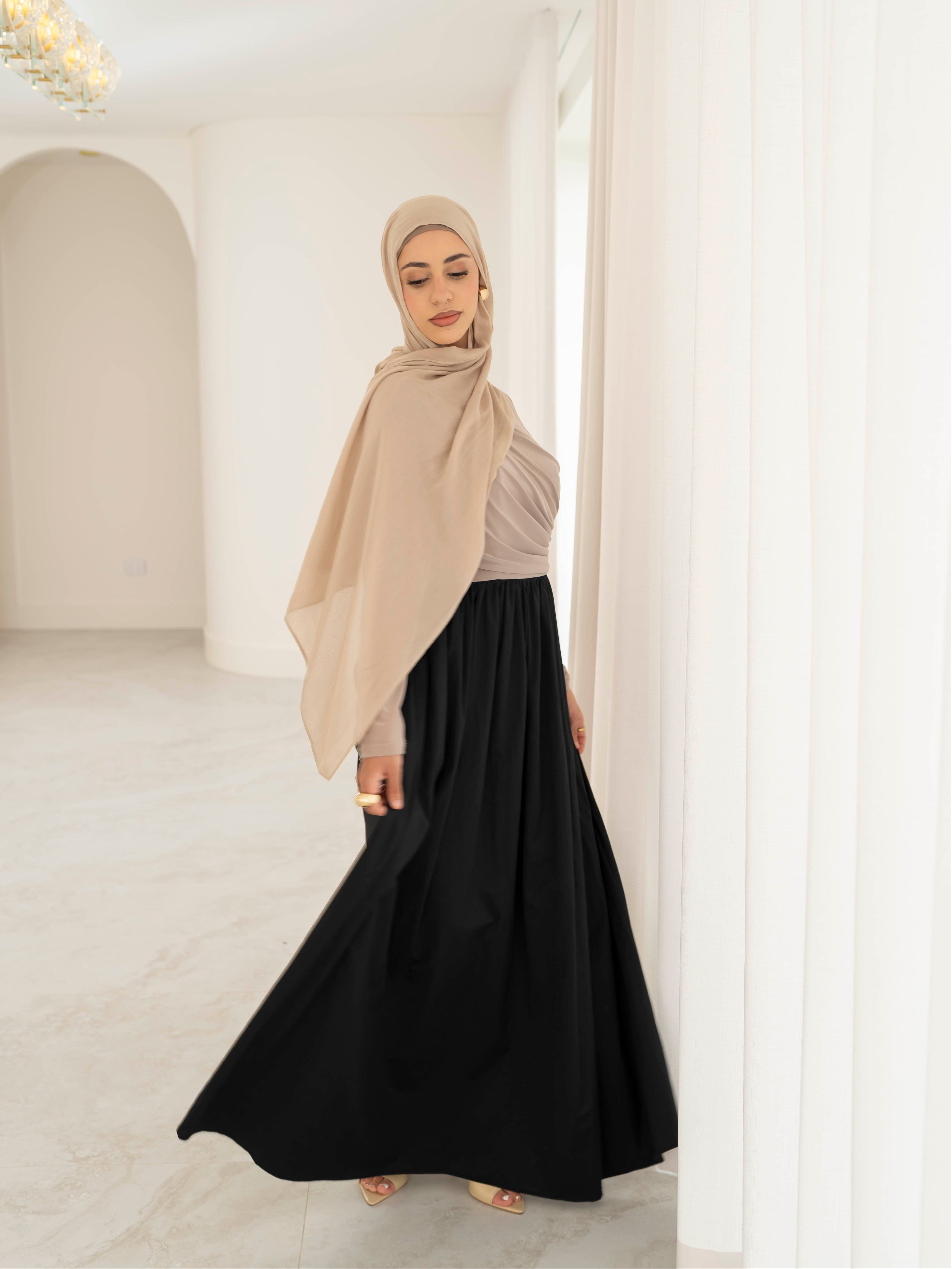 Model wearing the Aicha gathered dress featuring a jersey bodice and poplin skirt with soft gathered detailing, styled for a modest and elegant look suitable for Ramadan and Eid.
