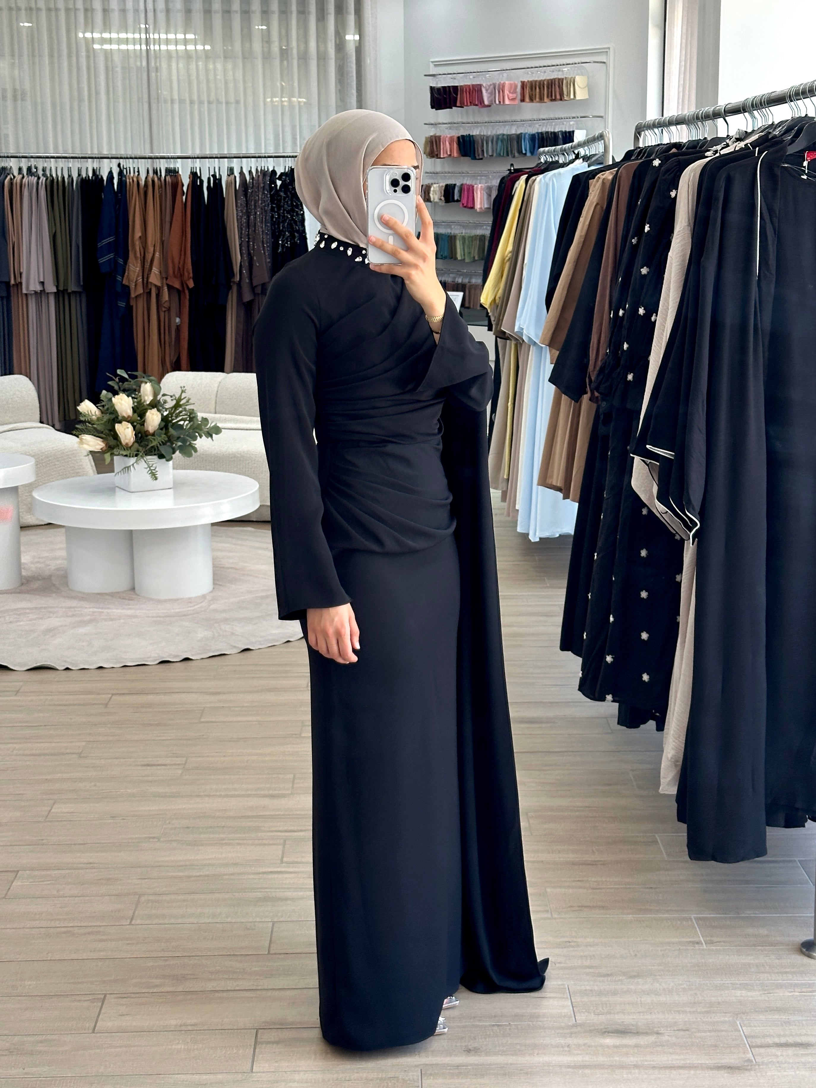 women's full length maxi formal dress in black with minimal jewel embellishment. Dress is fitted on the waist with ruching and a cape that drapes off the shoulders. elegant to wear to any event/ occasion, suitable for hijabis.