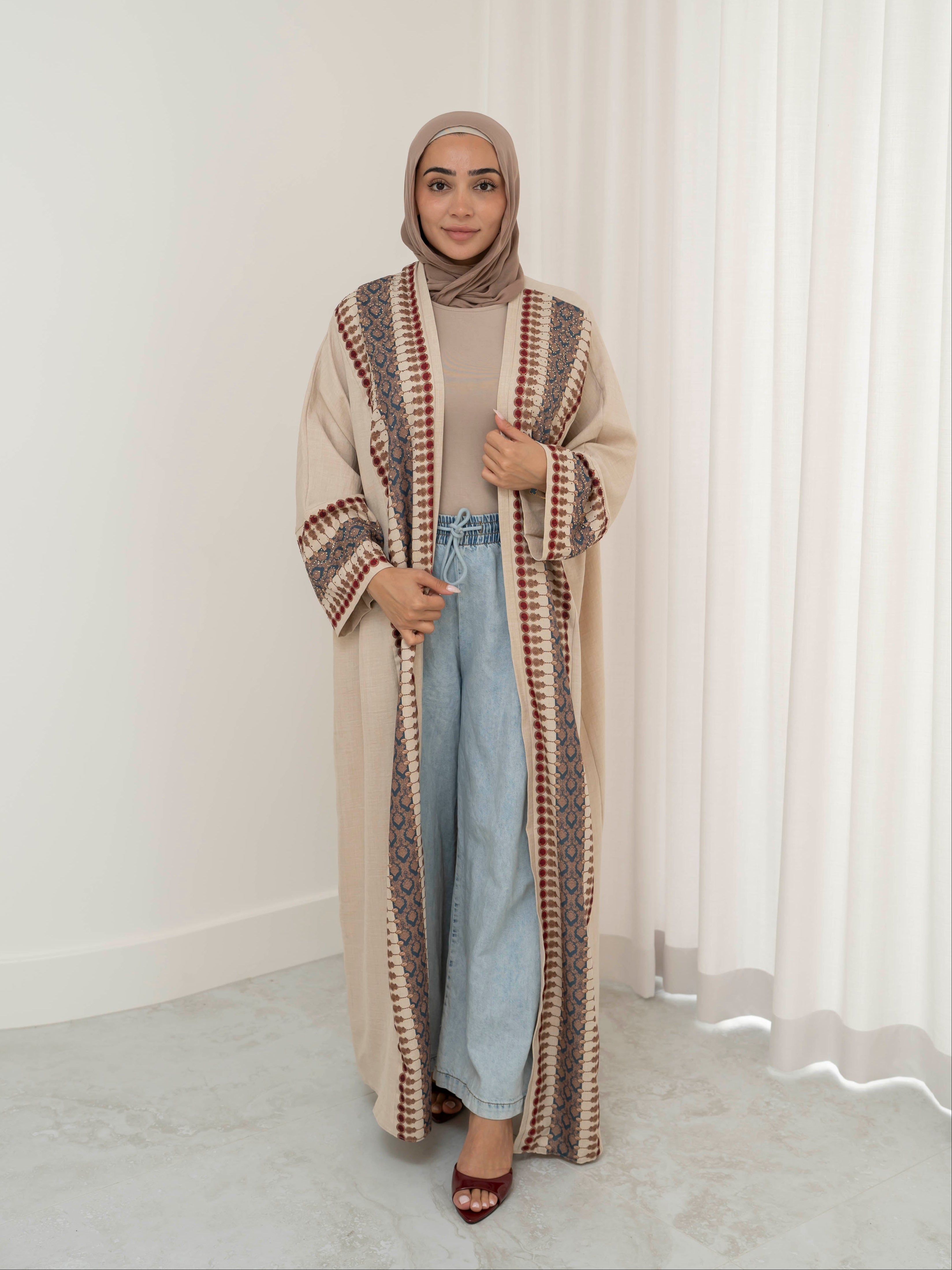 Model wearing the Andalus open abaya with an intricate patterned fabric and subtle embellishments, styled open for a modest and elegant look suitable for Ramadan and Eid.