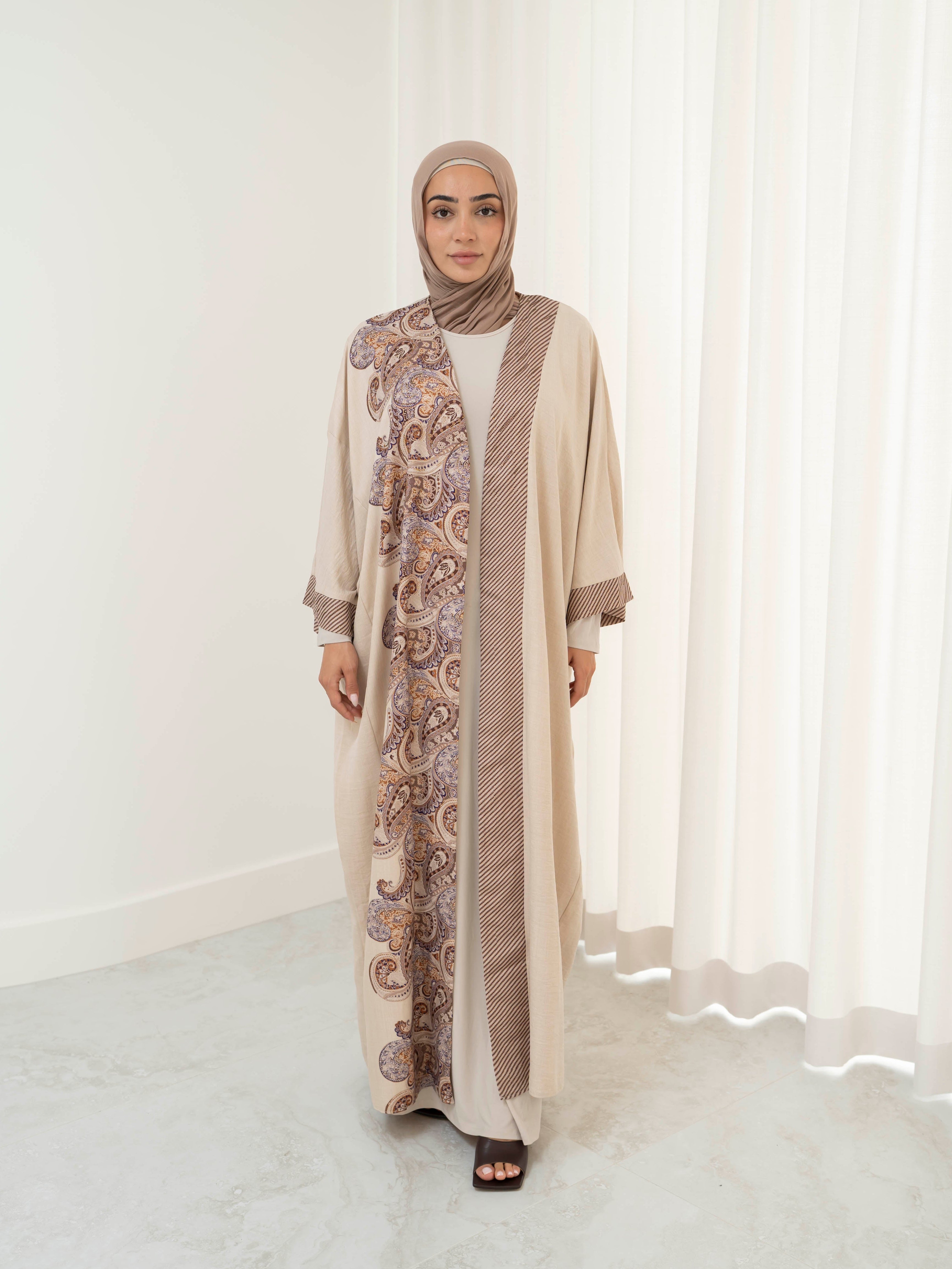 Model wearing the Marwa open abaya featuring a flowing silhouette with fine embellishment detailing, styled open for a modest and elegant look suitable for Ramadan and Eid.