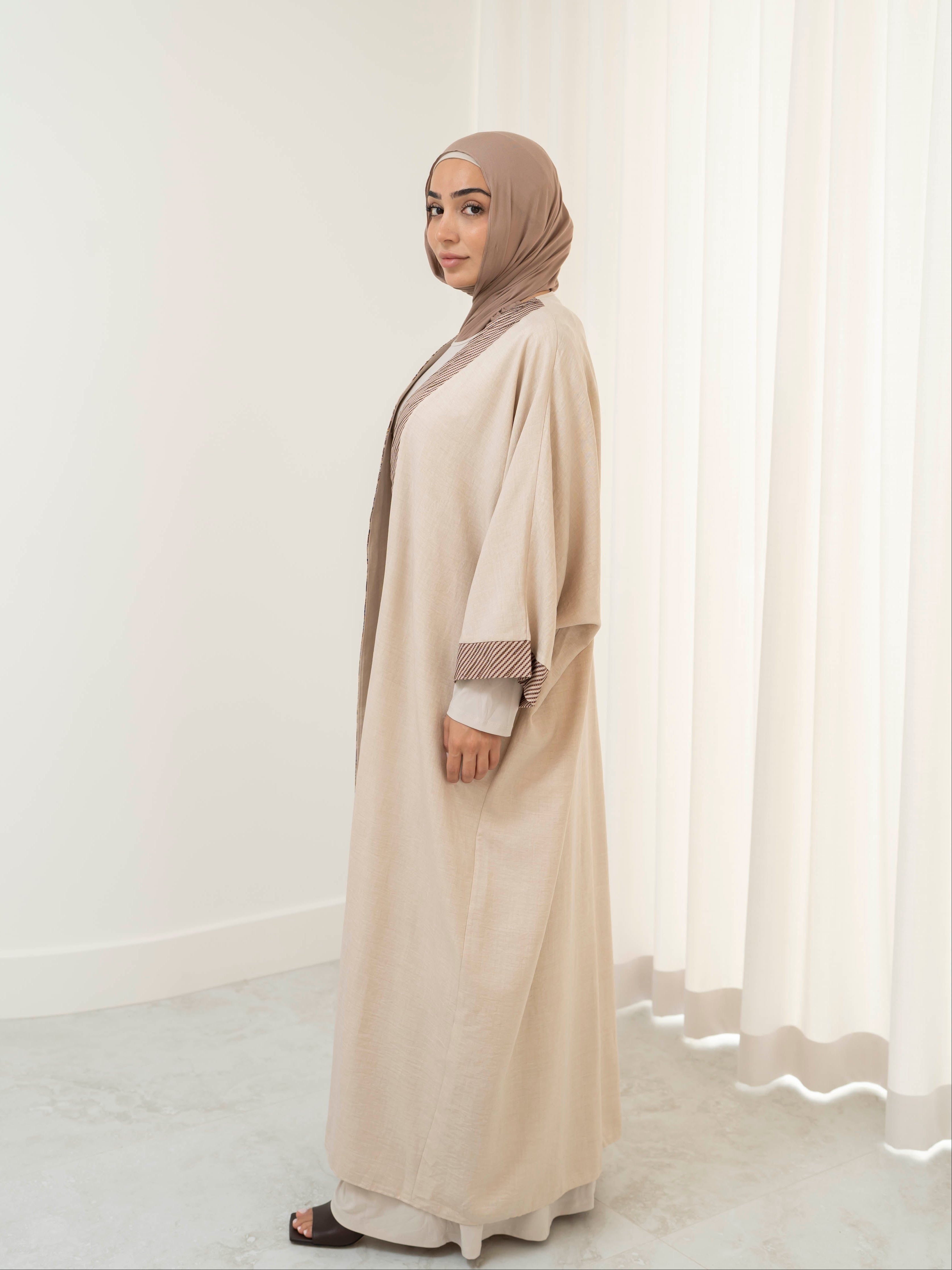 Model wearing the Marwa open abaya featuring a flowing silhouette with fine embellishment detailing, styled open for a modest and elegant look suitable for Ramadan and Eid.