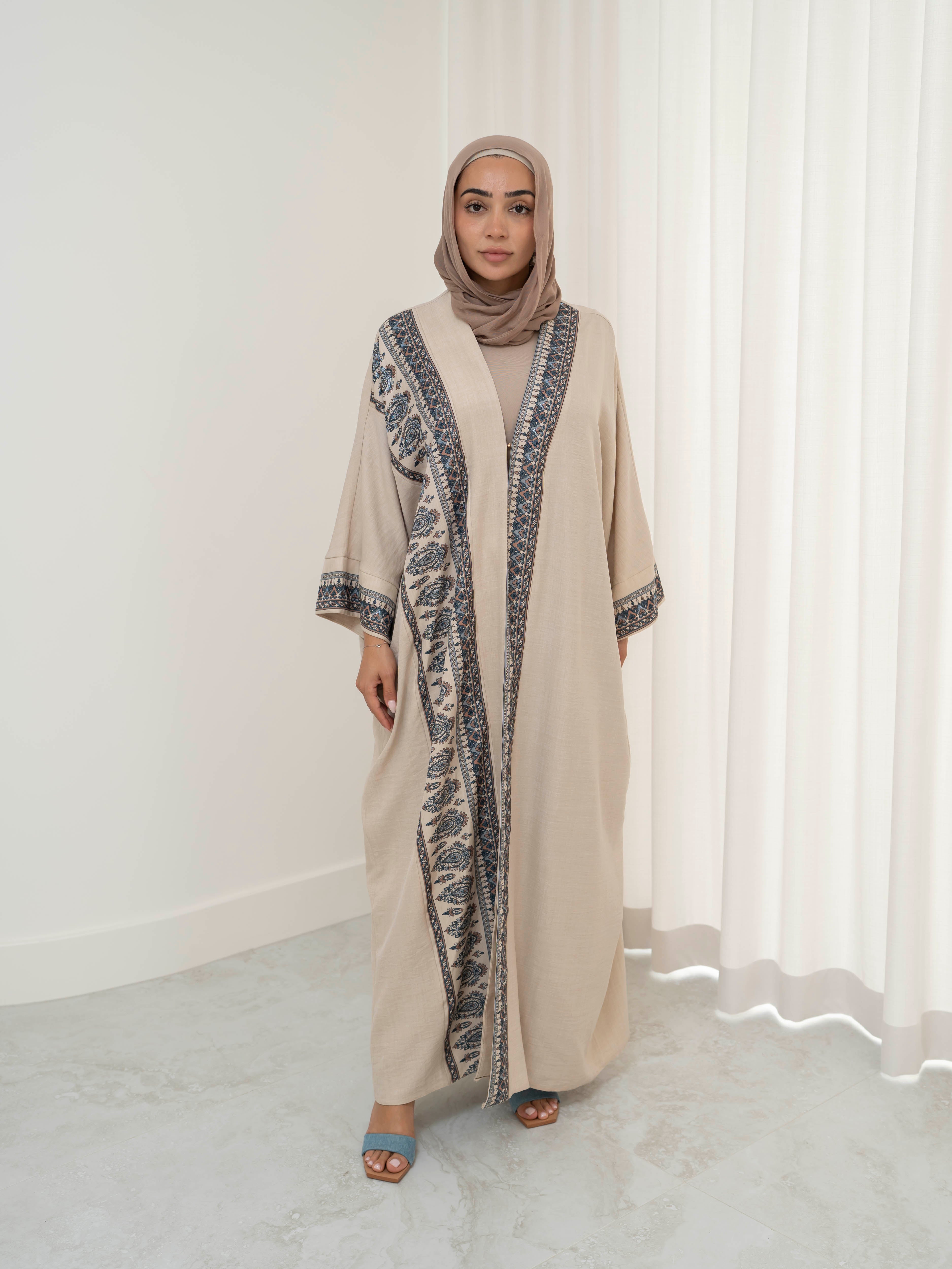Model wearing the Safiya open abaya featuring a subtle patterned fabric and delicate embellishments, styled open for a modest and elegant look suitable for Ramadan and Eid occasions.