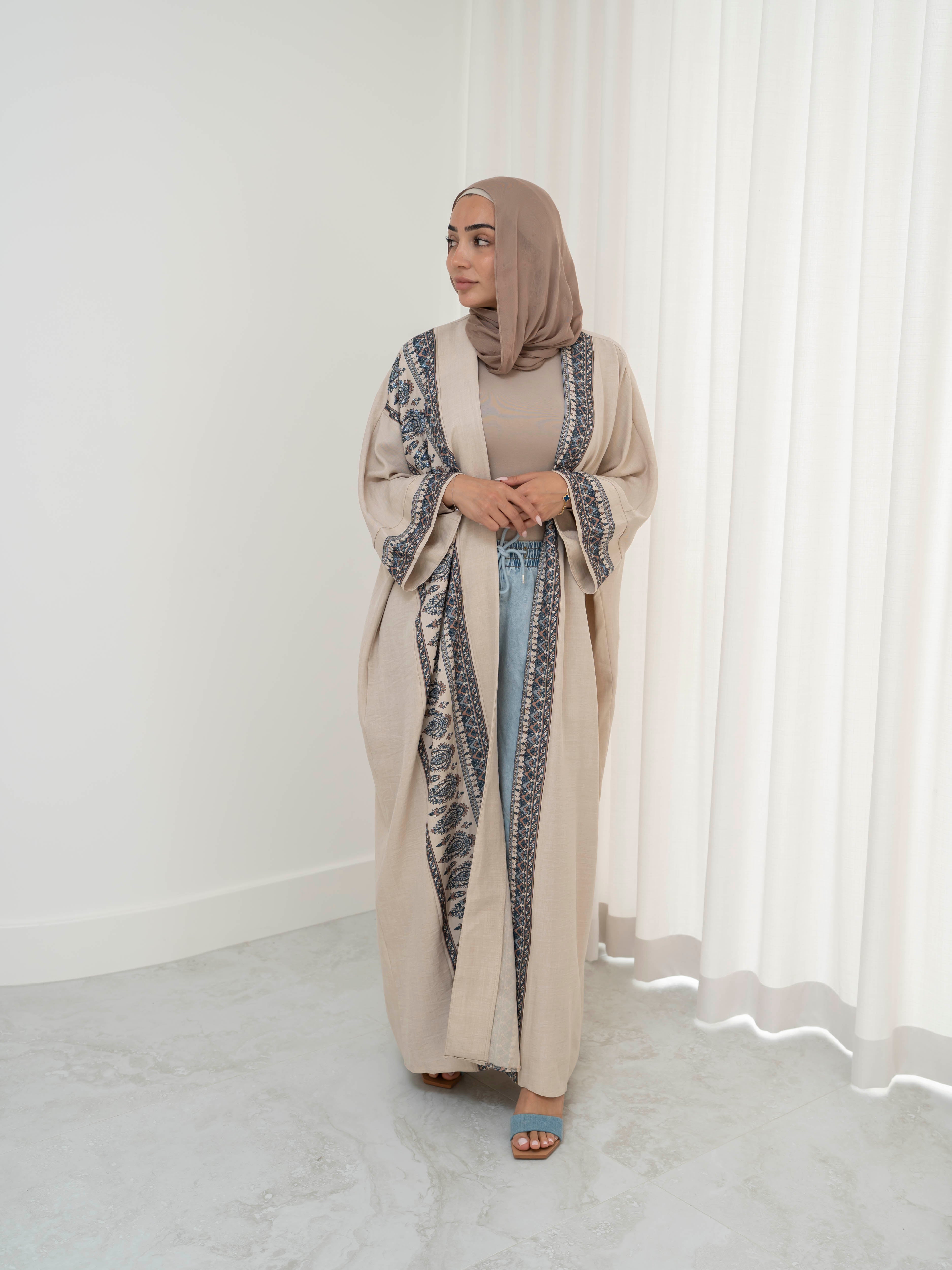 Model wearing the Safiya open abaya featuring a subtle patterned fabric and delicate embellishments, styled open for a modest and elegant look suitable for Ramadan and Eid occasions.