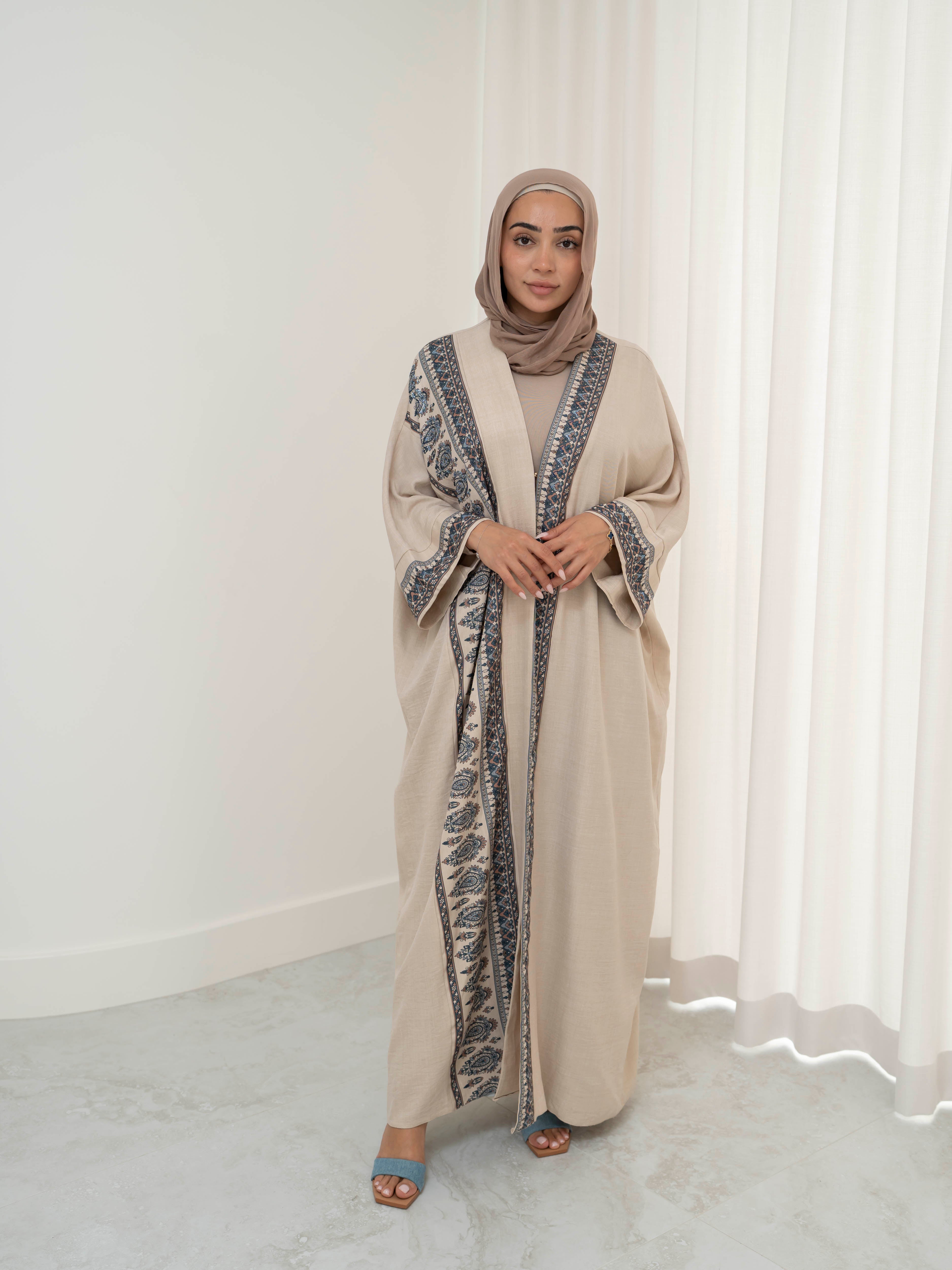Model wearing the Safiya open abaya featuring a subtle patterned fabric and delicate embellishments, styled open for a modest and elegant look suitable for Ramadan and Eid occasions.