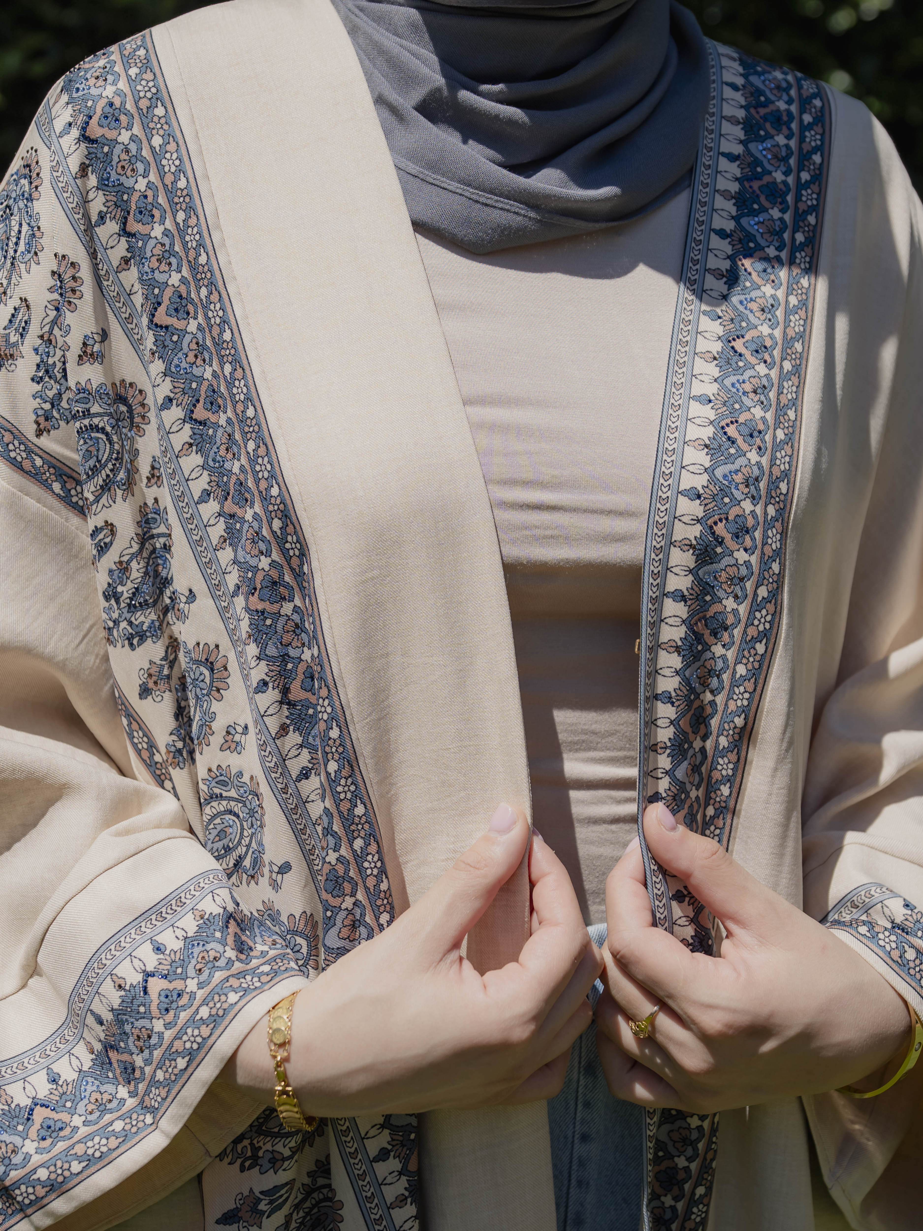 Model wearing the Safiya open abaya featuring a subtle patterned fabric and delicate embellishments, styled open for a modest and elegant look suitable for Ramadan and Eid occasions.