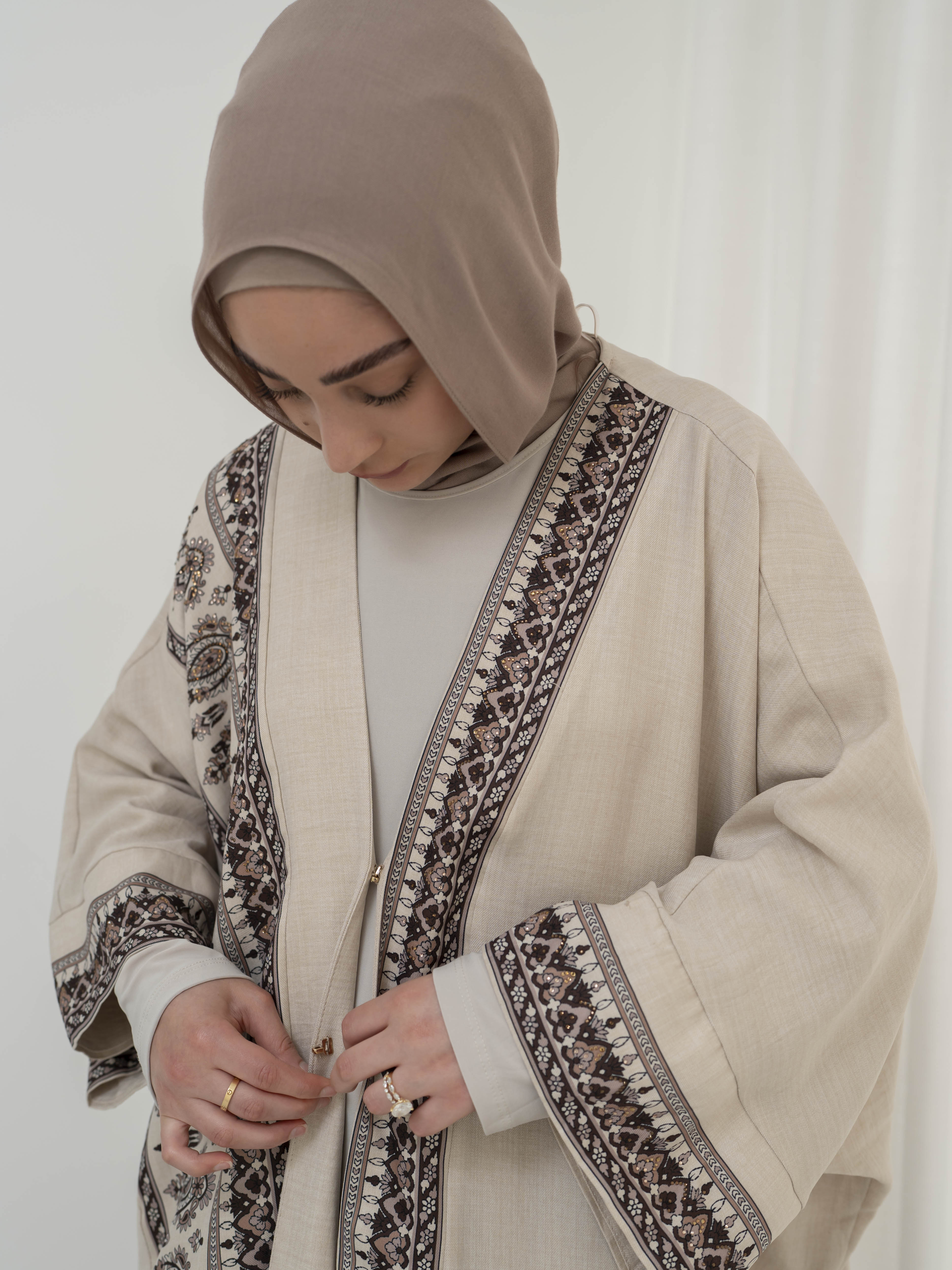 Model wearing the Safiya open abaya featuring a subtle patterned fabric and delicate embellishments, styled open for a modest and elegant look suitable for Ramadan and Eid occasions.