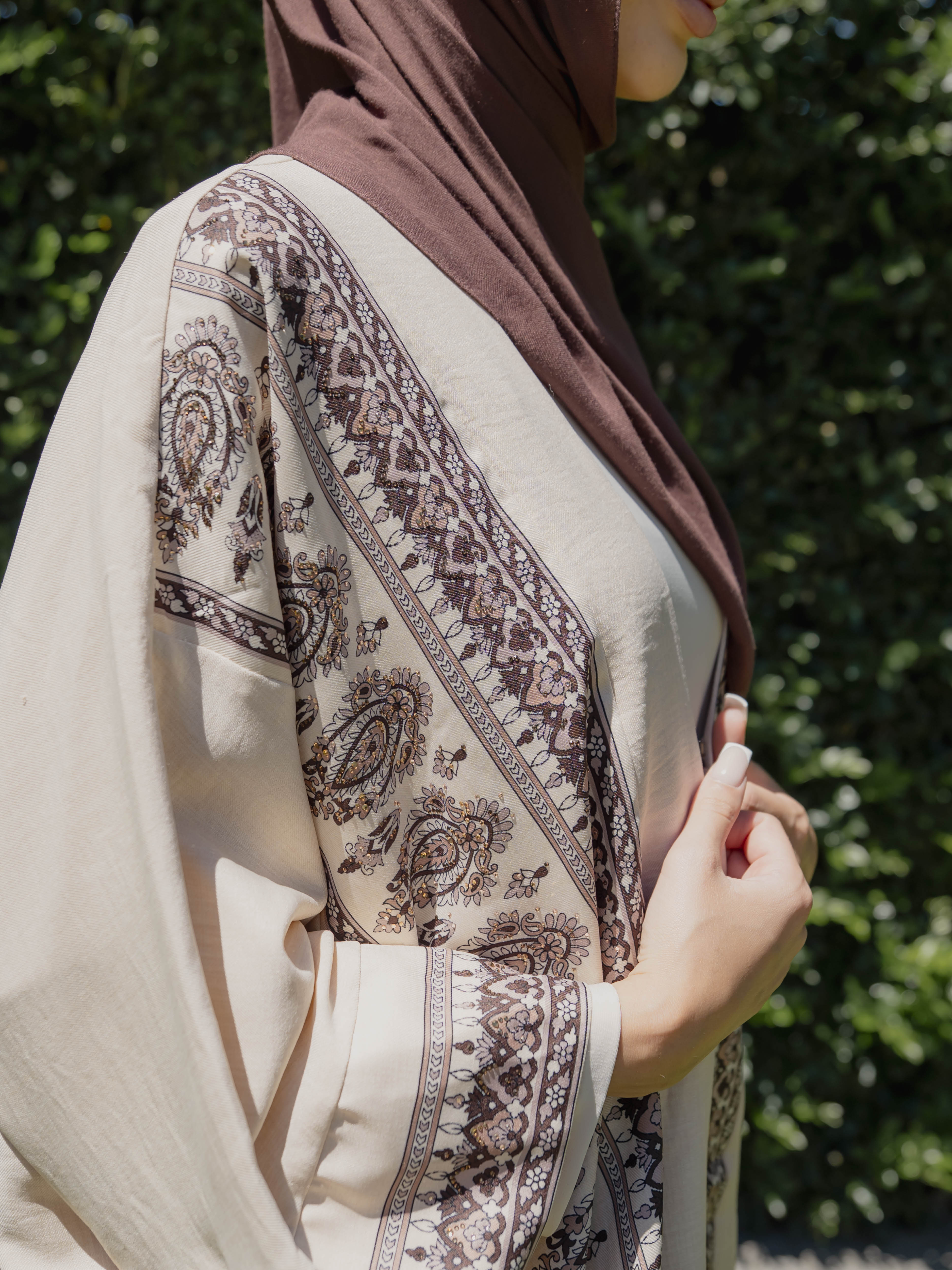 Model wearing the Safiya open abaya featuring a subtle patterned fabric and delicate embellishments, styled open for a modest and elegant look suitable for Ramadan and Eid occasions.
