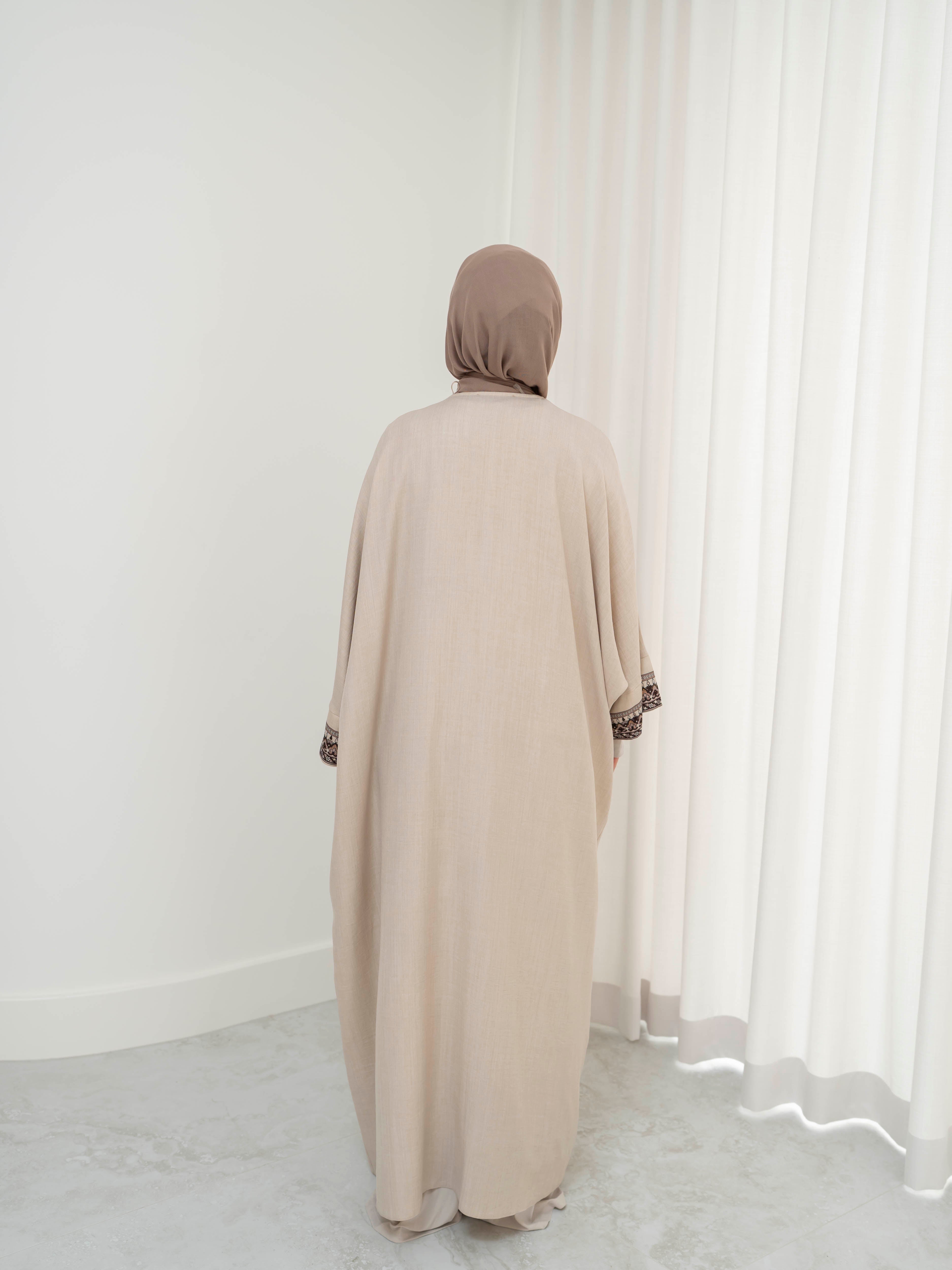 Model wearing the Safiya open abaya featuring a subtle patterned fabric and delicate embellishments, styled open for a modest and elegant look suitable for Ramadan and Eid occasions.