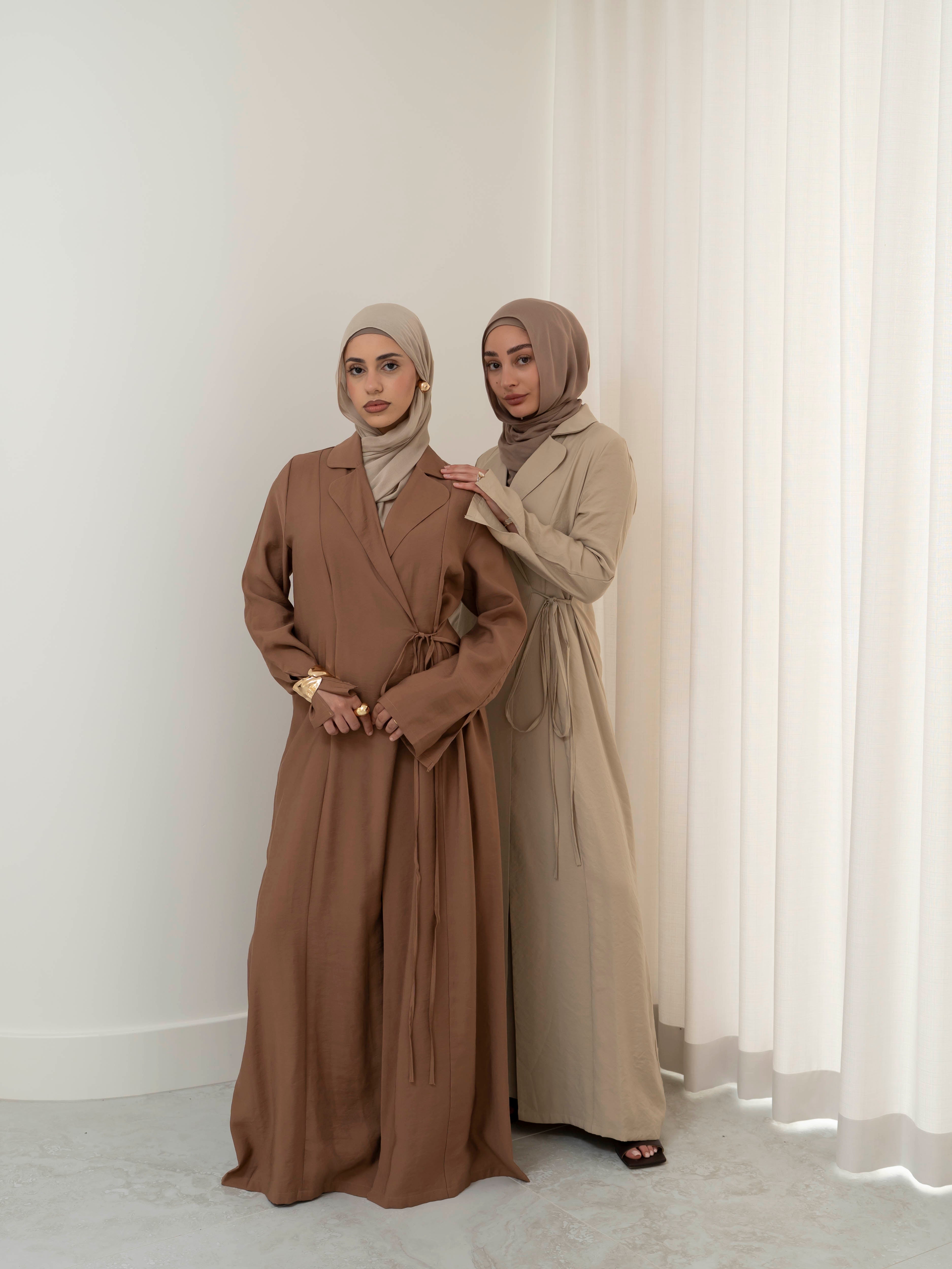 Alya Tie Dress, a full-length dress with adjustable waist tie, lapel neckline, and long sleeves with cuff finish. Lightweight fabric with soft drape, offering a modest, elegant silhouette for Eid, formal occasions, or refined everyday wear.