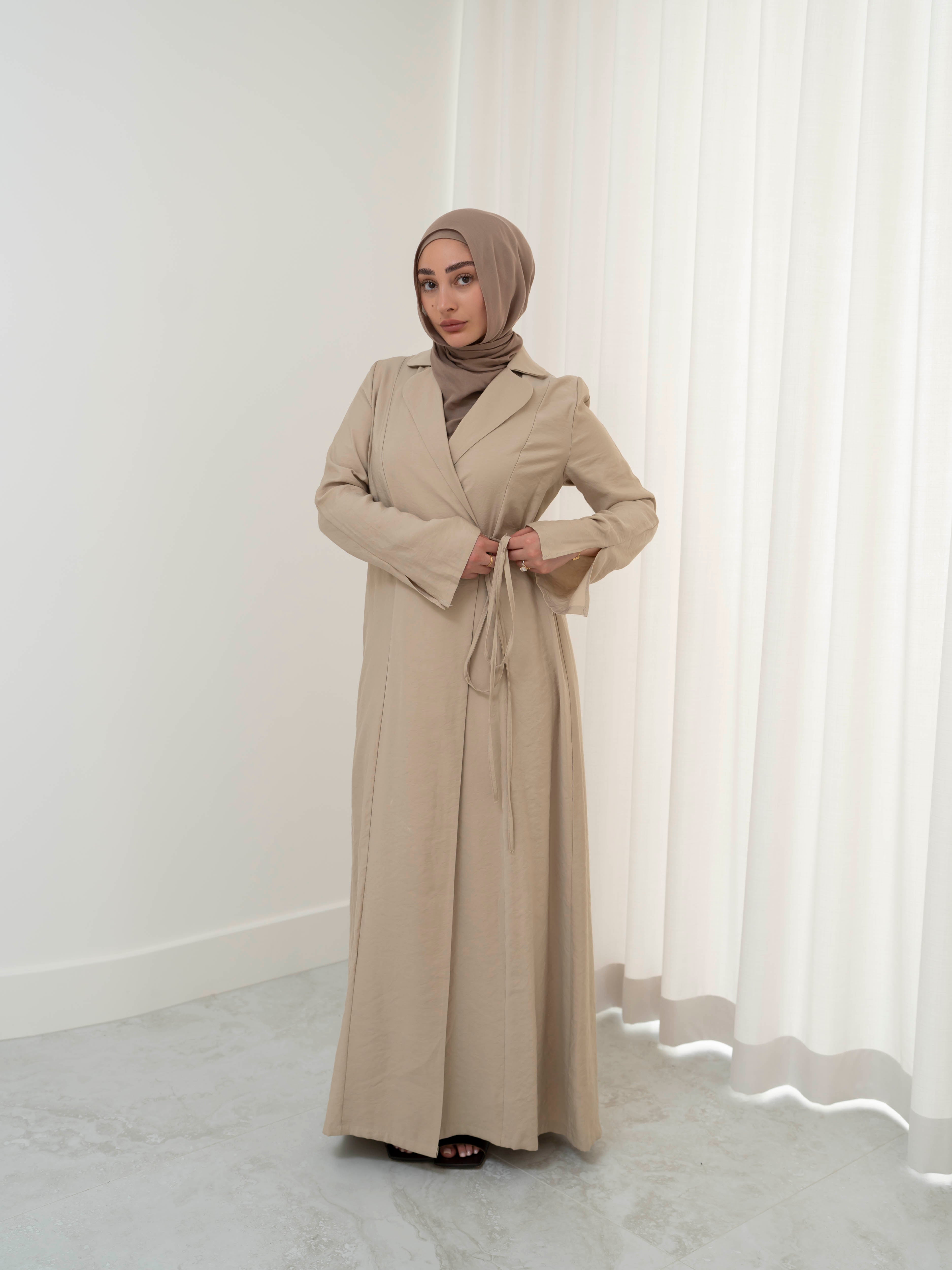 Alya Tie Dress, a full-length dress with adjustable waist tie, lapel neckline, and long sleeves with cuff finish. Lightweight fabric with soft drape, offering a modest, elegant silhouette for Eid, formal occasions, or refined everyday wear.
