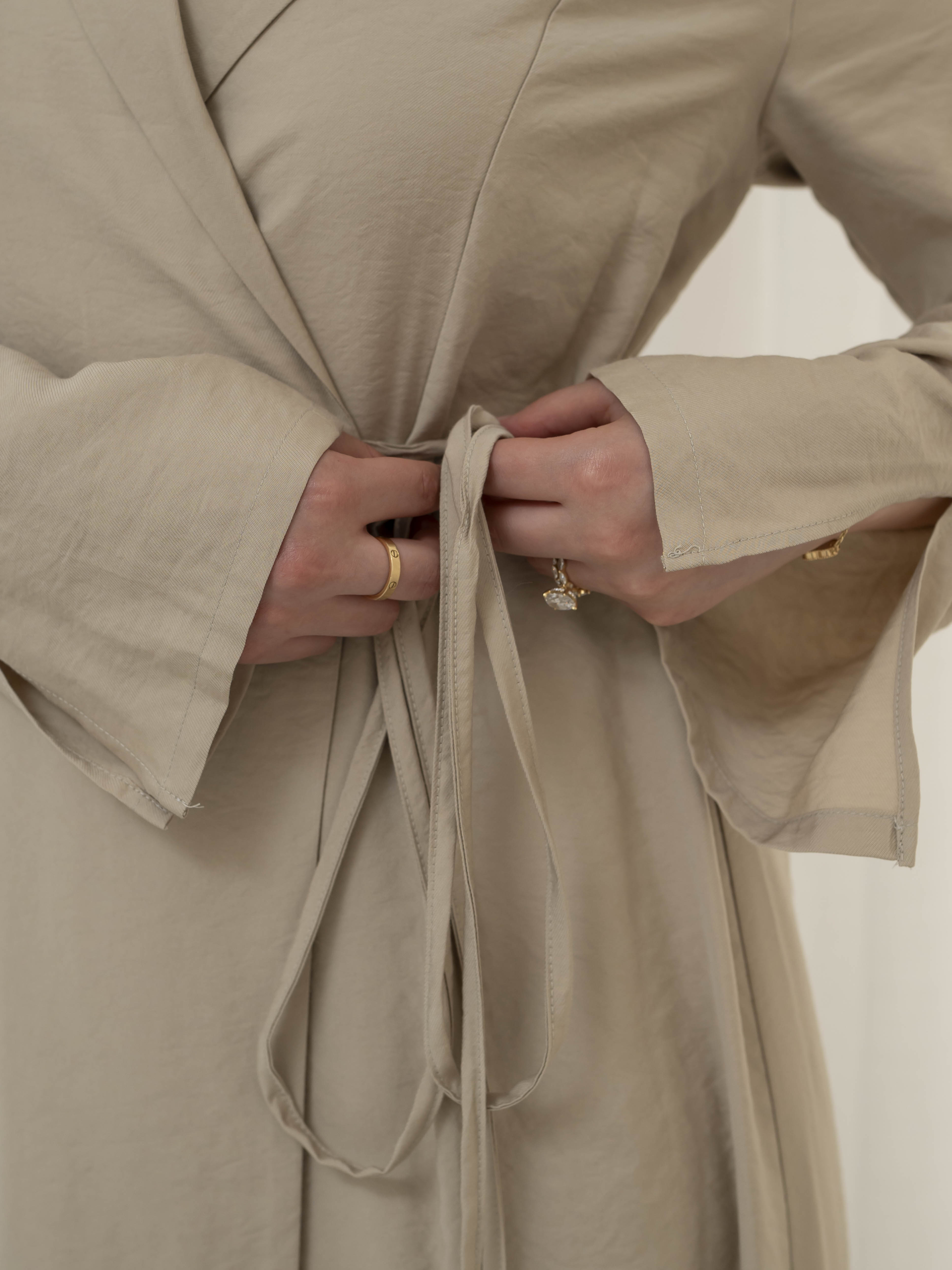 Alya Tie Dress, a full-length dress with adjustable waist tie, lapel neckline, and long sleeves with cuff finish. Lightweight fabric with soft drape, offering a modest, elegant silhouette for Eid, formal occasions, or refined everyday wear.