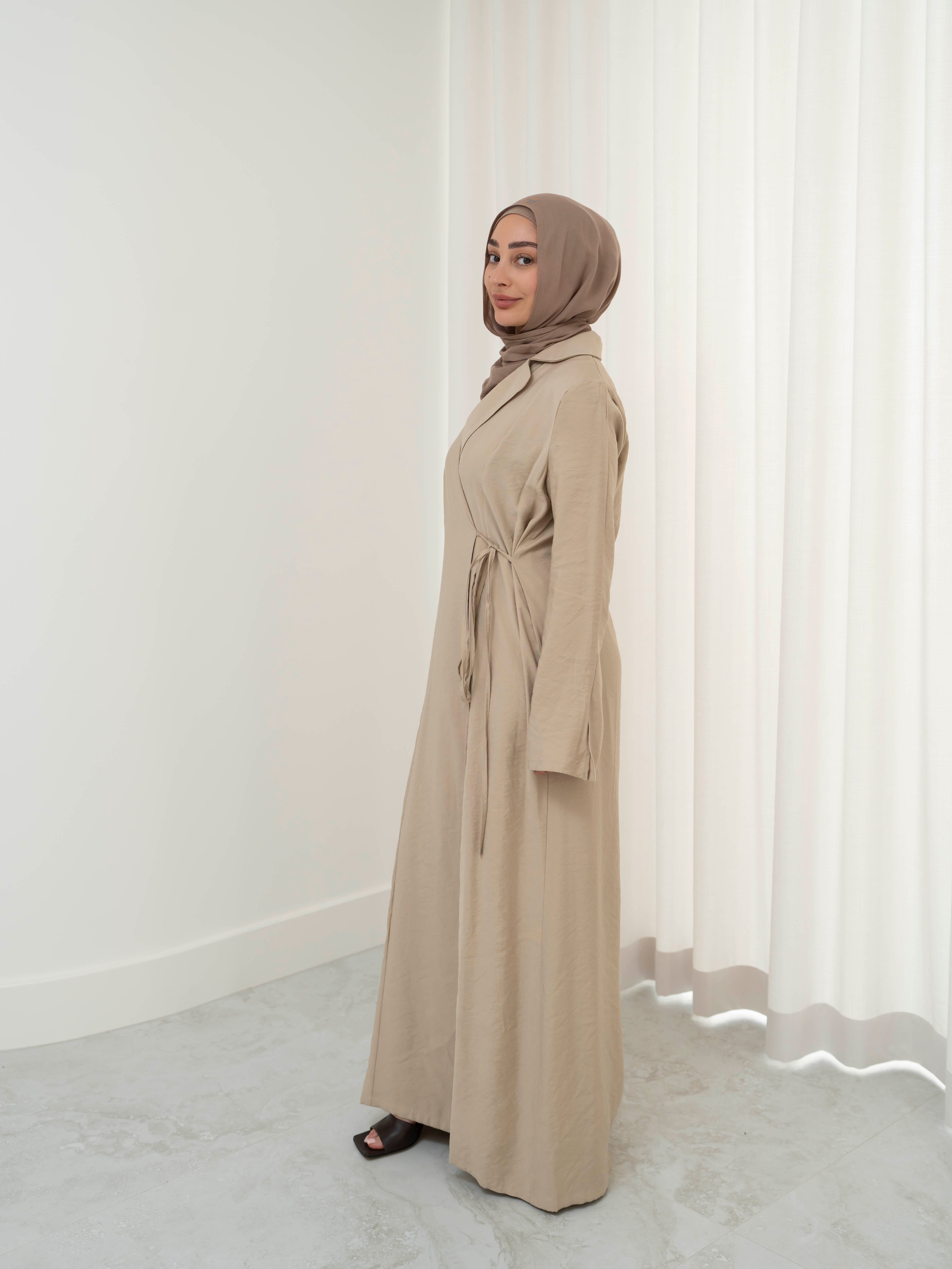 Alya Tie Dress, a full-length dress with adjustable waist tie, lapel neckline, and long sleeves with cuff finish. Lightweight fabric with soft drape, offering a modest, elegant silhouette for Eid, formal occasions, or refined everyday wear.
