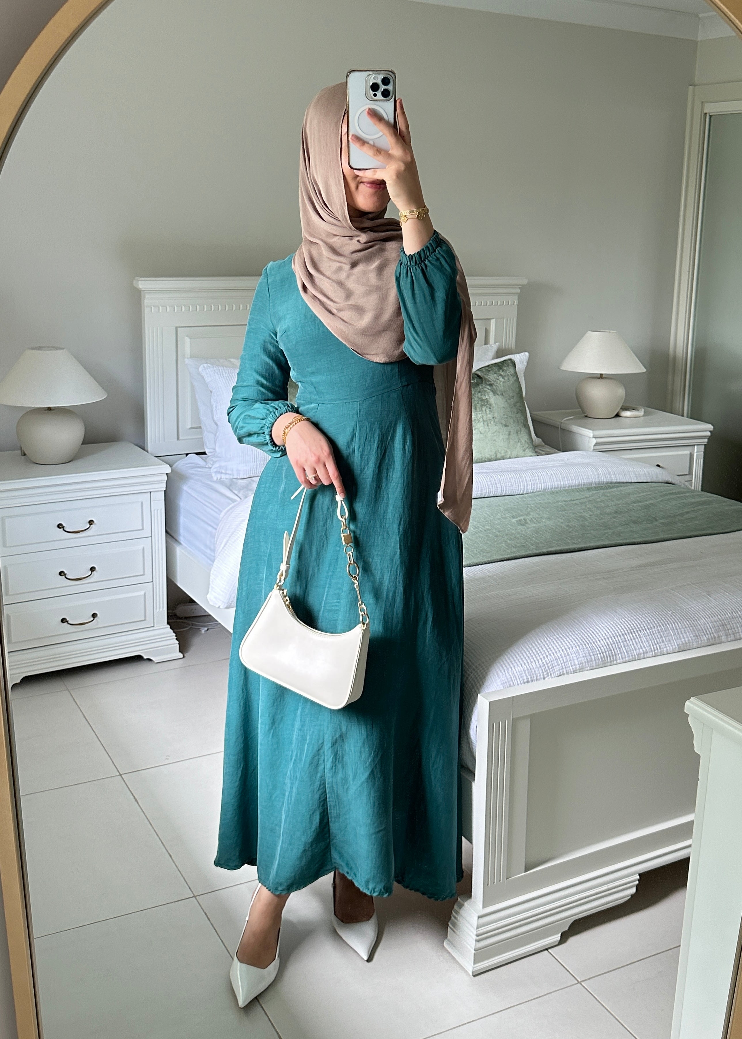 Amira Linen Dress in a soft linen-blend fabric with long sleeves and a fitted bodice featuring limited stretch. Designed with an empire waist that flows into a loose high-low skirt for an elegant, flattering silhouette suitable for special occasions.