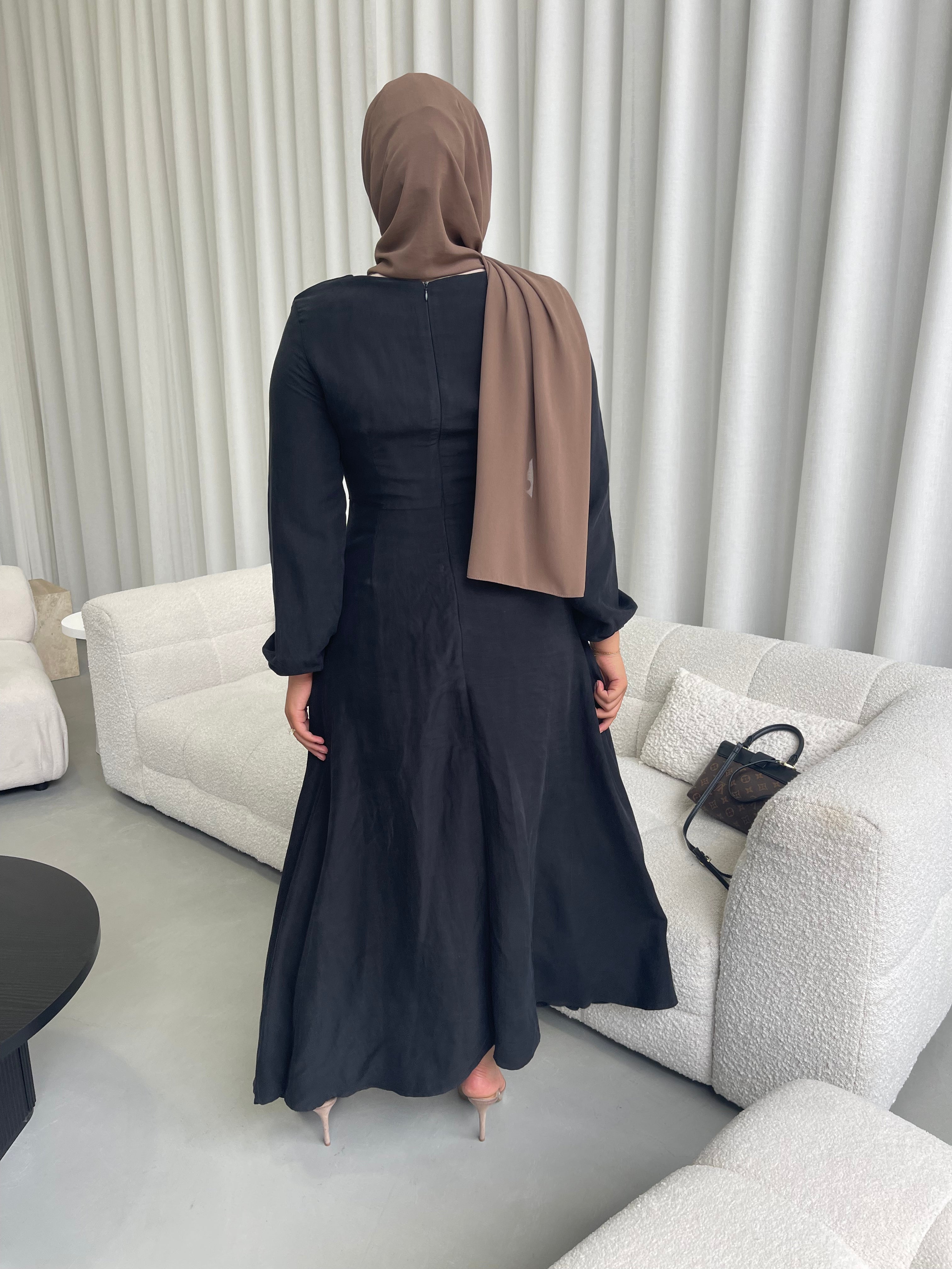 Amira Dress in linen-viscose fabric with long sleeves and a fitted bodice featuring an empire waist and limited stretch. Flows into a loose high-low skirt for an elegant silhouette, suitable for special occasions or styled with heels.