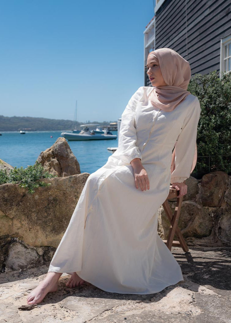 Ivory linen maxi dress with an A-line skirt and empire waist for a flattering silhouette. Features a round neckline and long balloon sleeves for an elegant touch. Lightweight and breathable, ideal for warm-weather wear and summer occasions.