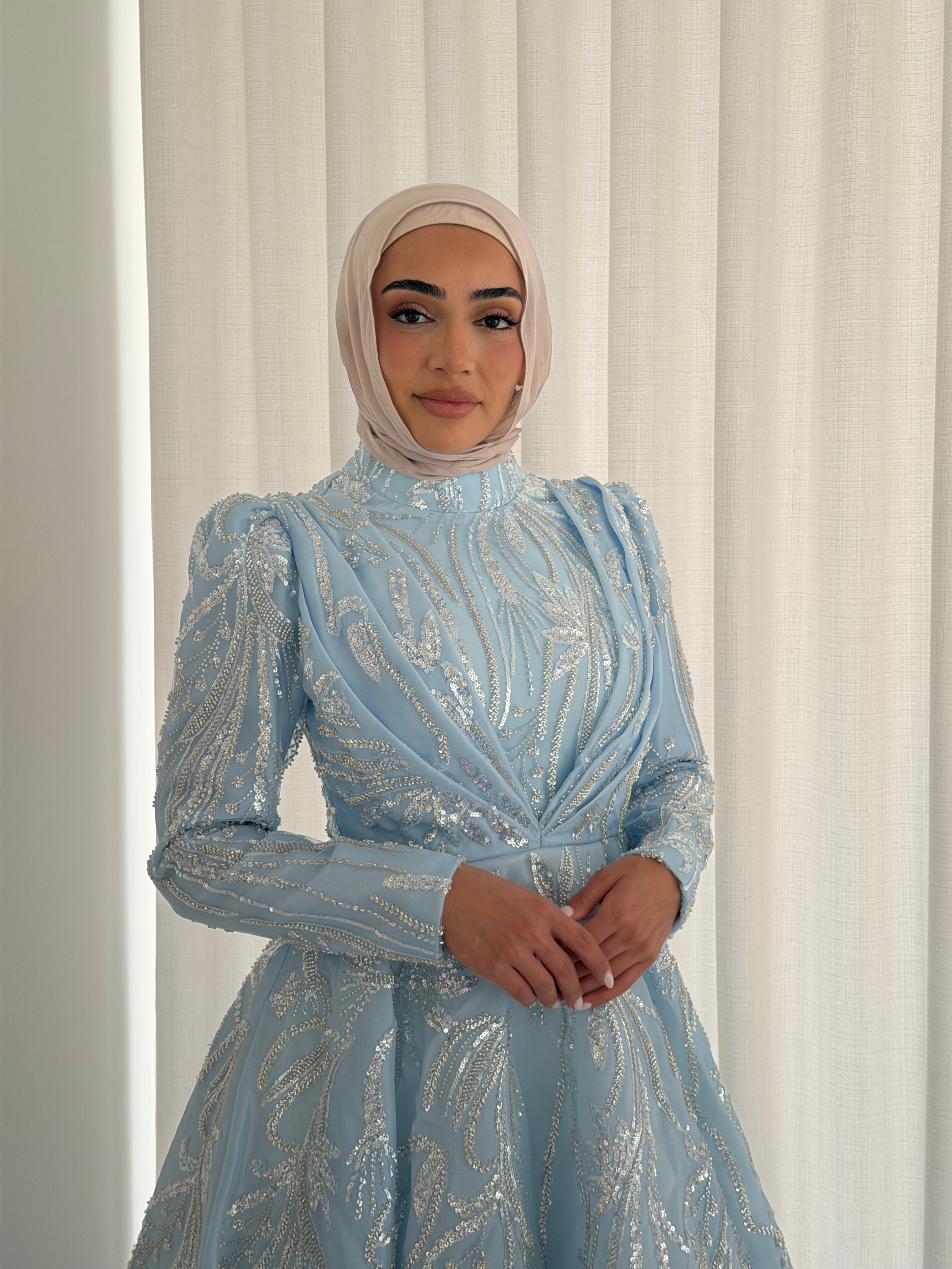 The modest silhouette offers full coverage while the shimmering surface adds a touch of effortless glamour, making it perfect for evenings, formal events, or special occasions.