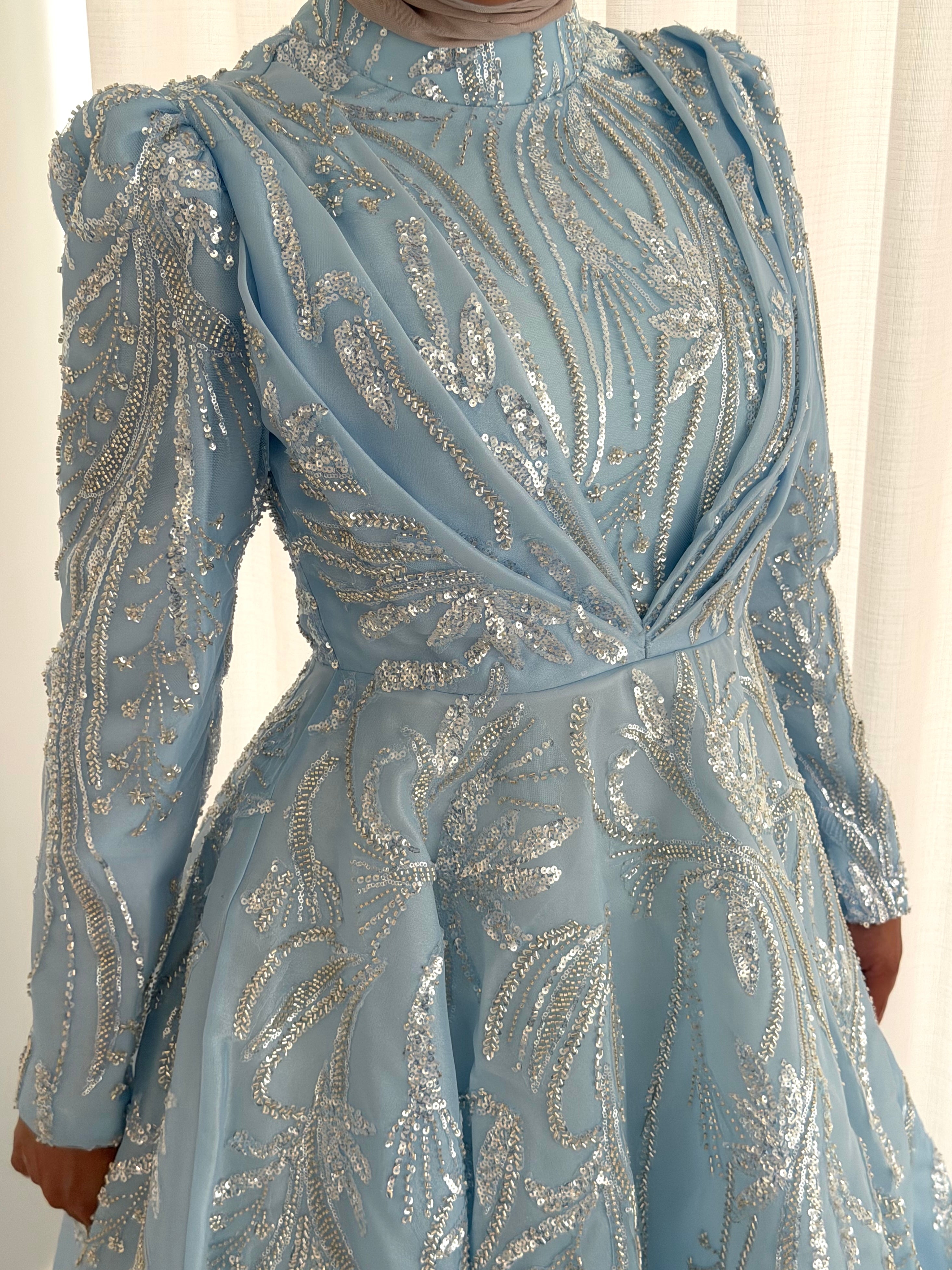 The modest silhouette offers full coverage while the shimmering surface adds a touch of effortless glamour, making it perfect for evenings, formal events, or special occasions.