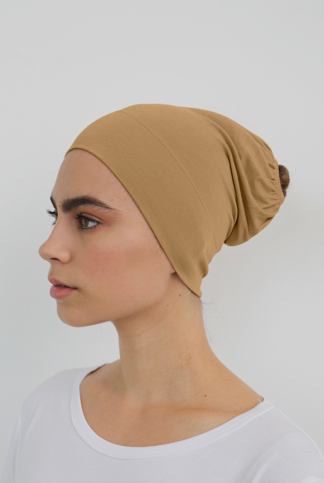 Bamboo under-scarf cap designed to cover hair beneath a hijab, made from soft, breathable natural bamboo fibers with cotton spandex stretch for comfort. Partially closed at the back with an elastic edge to comfortably accommodate hair.
