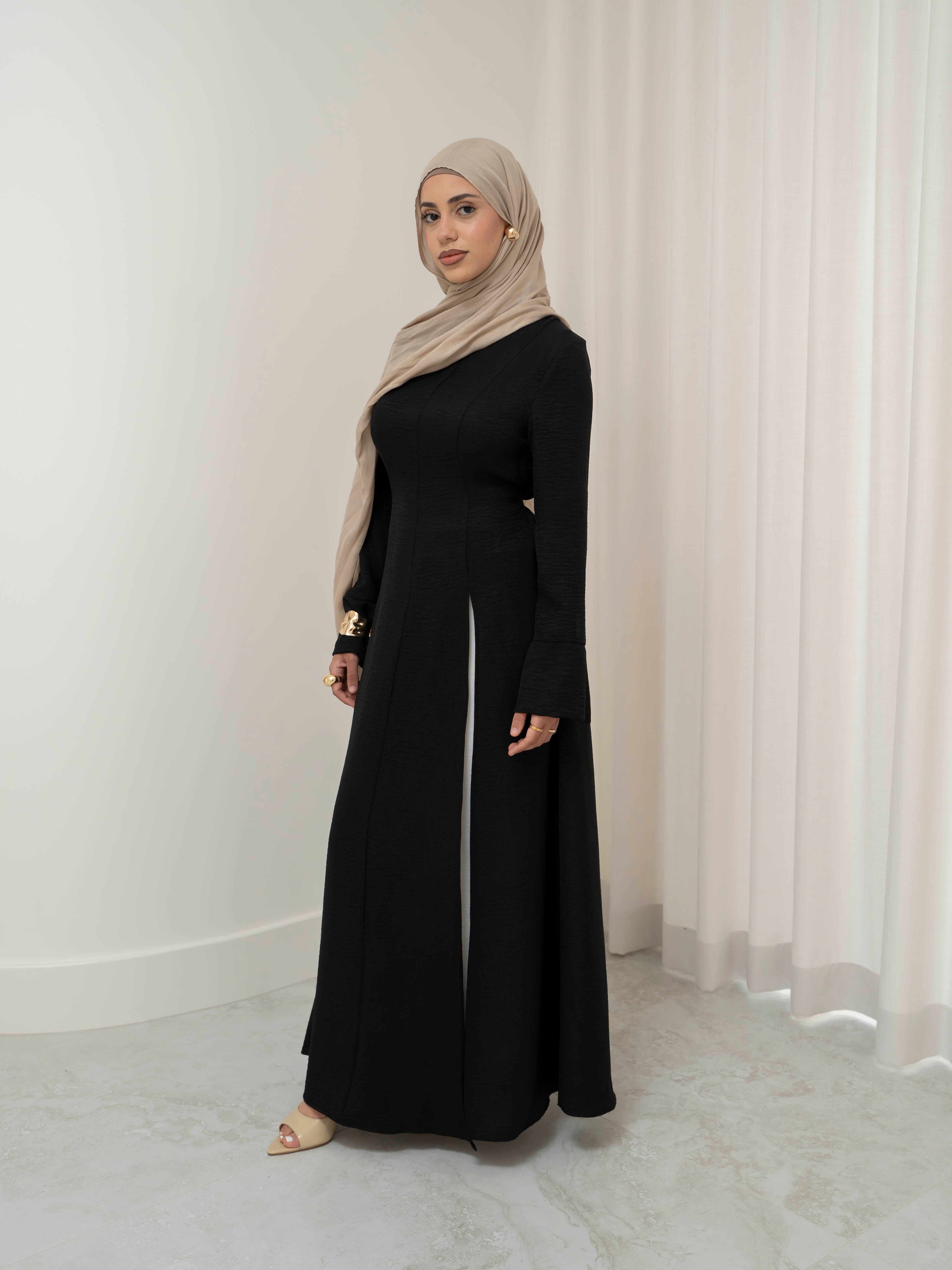 Isla Panelled Dress Set, a two-piece outfit with a tailored outer dress and contrasting inner skirt in a structured, full-length design. Features long sleeves with cuffs, an adjustable waist tie, and lightweight fabric with elegant drape, offering a modest and polished look for formal occasions or Eid.