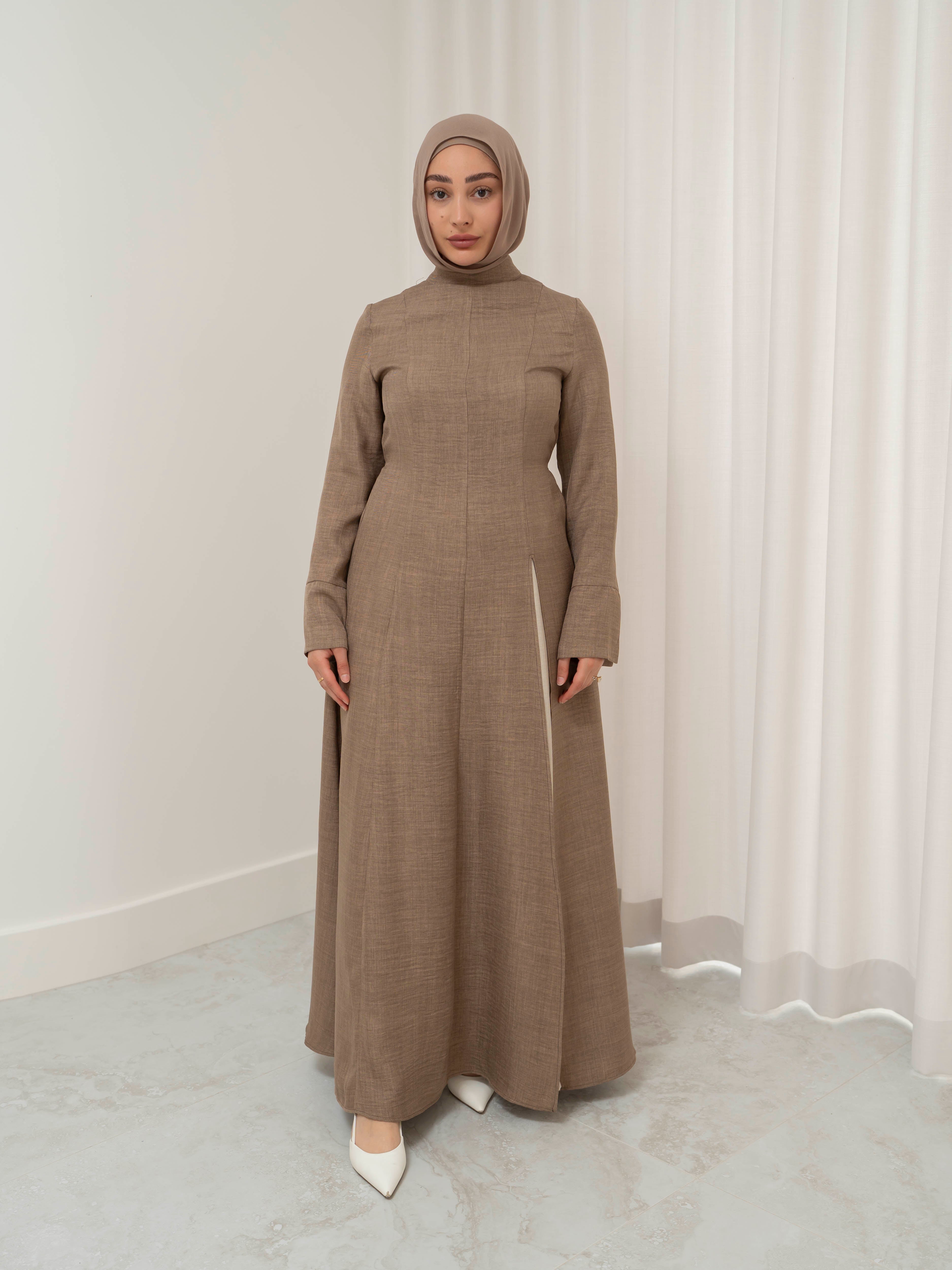 Isla Panelled Dress Set, a two-piece outfit with a tailored outer dress and contrasting inner skirt in a structured, full-length design. Features long sleeves with cuffs, an adjustable waist tie, and lightweight fabric with elegant drape, offering a modest and polished look for formal occasions or Eid.