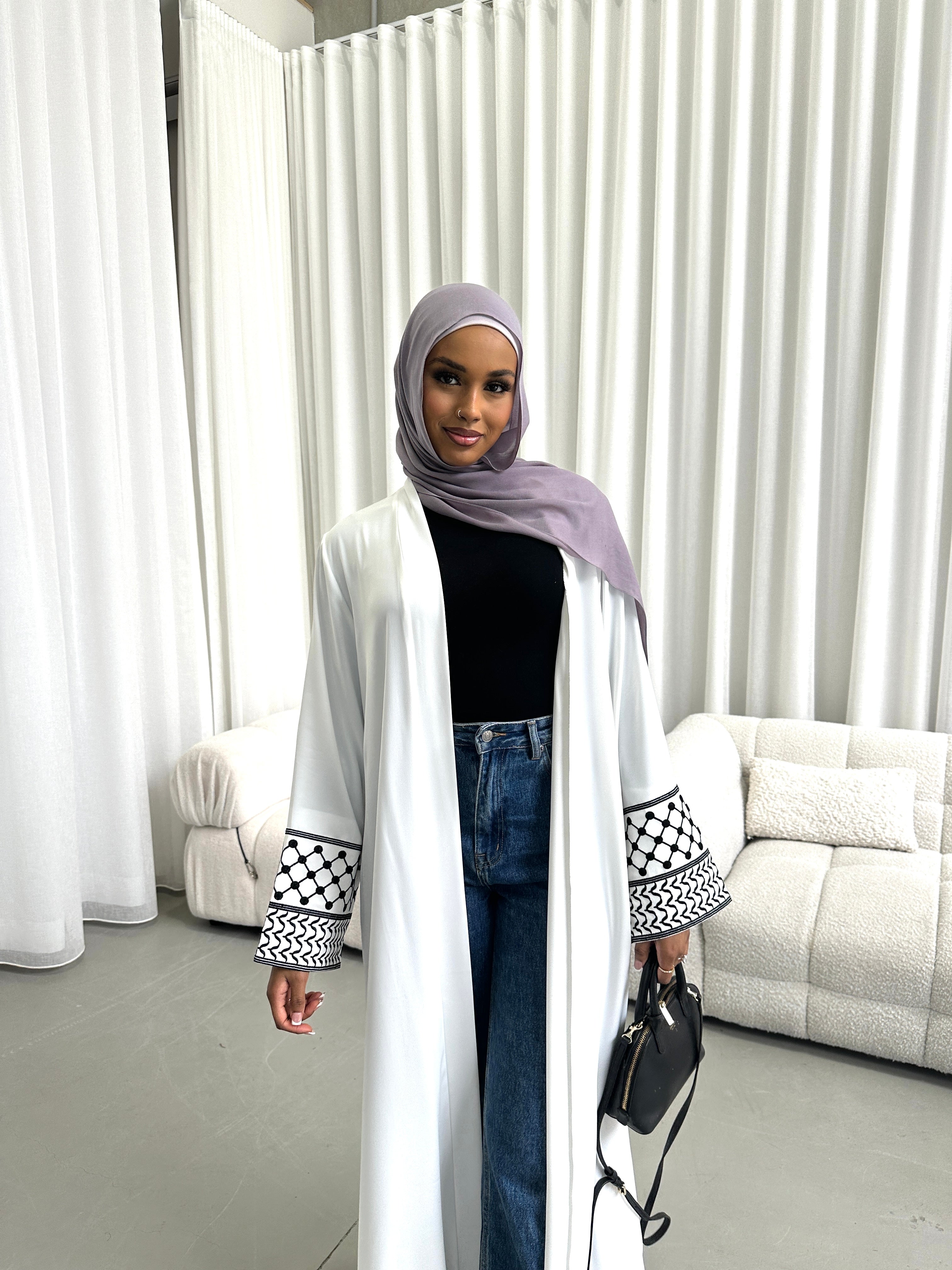Show your support for Palestine with the KEFFIYEH SLEEVE ABAYA. With signature Palestinian craft printed on the wide sleeve cuffs, this dress effortlessly combines modesty and comfort. The wrap-inspired silhouette features a self-fastening tie wrap, maxi length hem. Wear yours to public social gatherings to show where you stand!&nbsp;