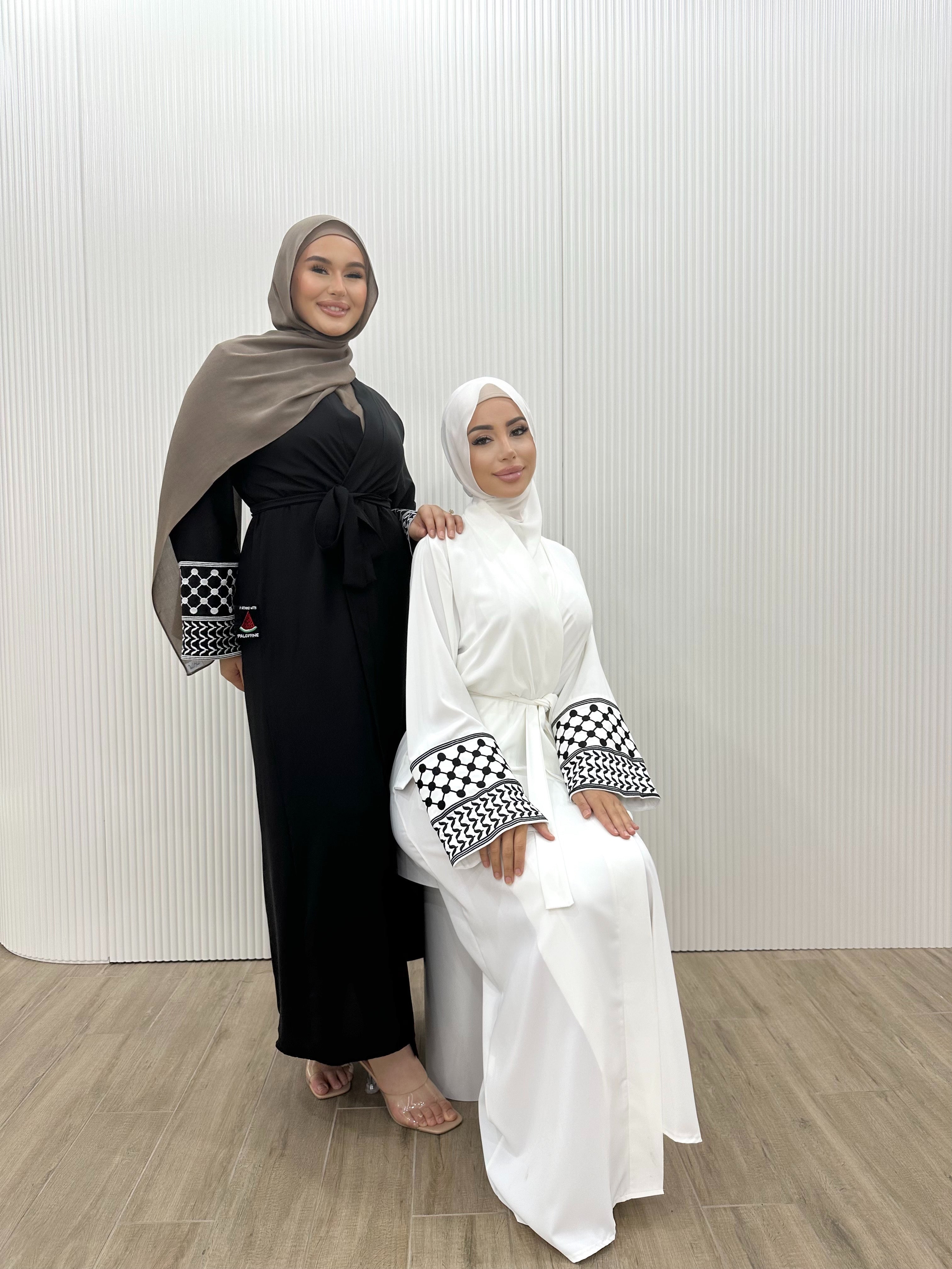 Show your support for Palestine with the KEFFIYEH SLEEVE ABAYA. With signature Palestinian craft printed on the wide sleeve cuffs, this dress effortlessly combines modesty and comfort. The wrap-inspired silhouette features a self-fastening tie wrap, maxi length hem. Wear yours to public social gatherings to show where you stand!&nbsp;