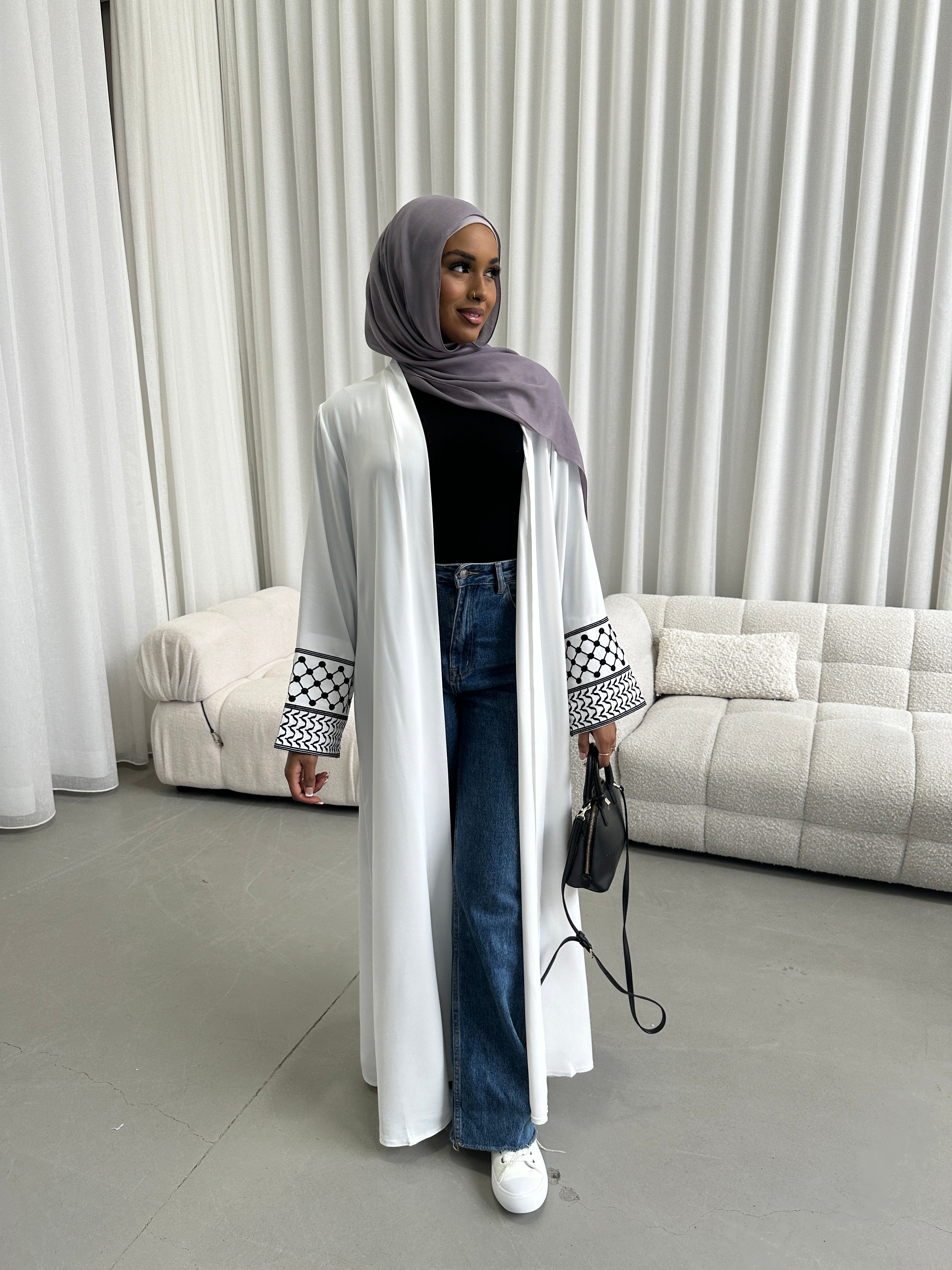 Show your support for Palestine with the KEFFIYEH SLEEVE ABAYA. With signature Palestinian craft printed on the wide sleeve cuffs, this dress effortlessly combines modesty and comfort. The wrap-inspired silhouette features a self-fastening tie wrap, maxi length hem. Wear yours to public social gatherings to show where you stand!&nbsp;