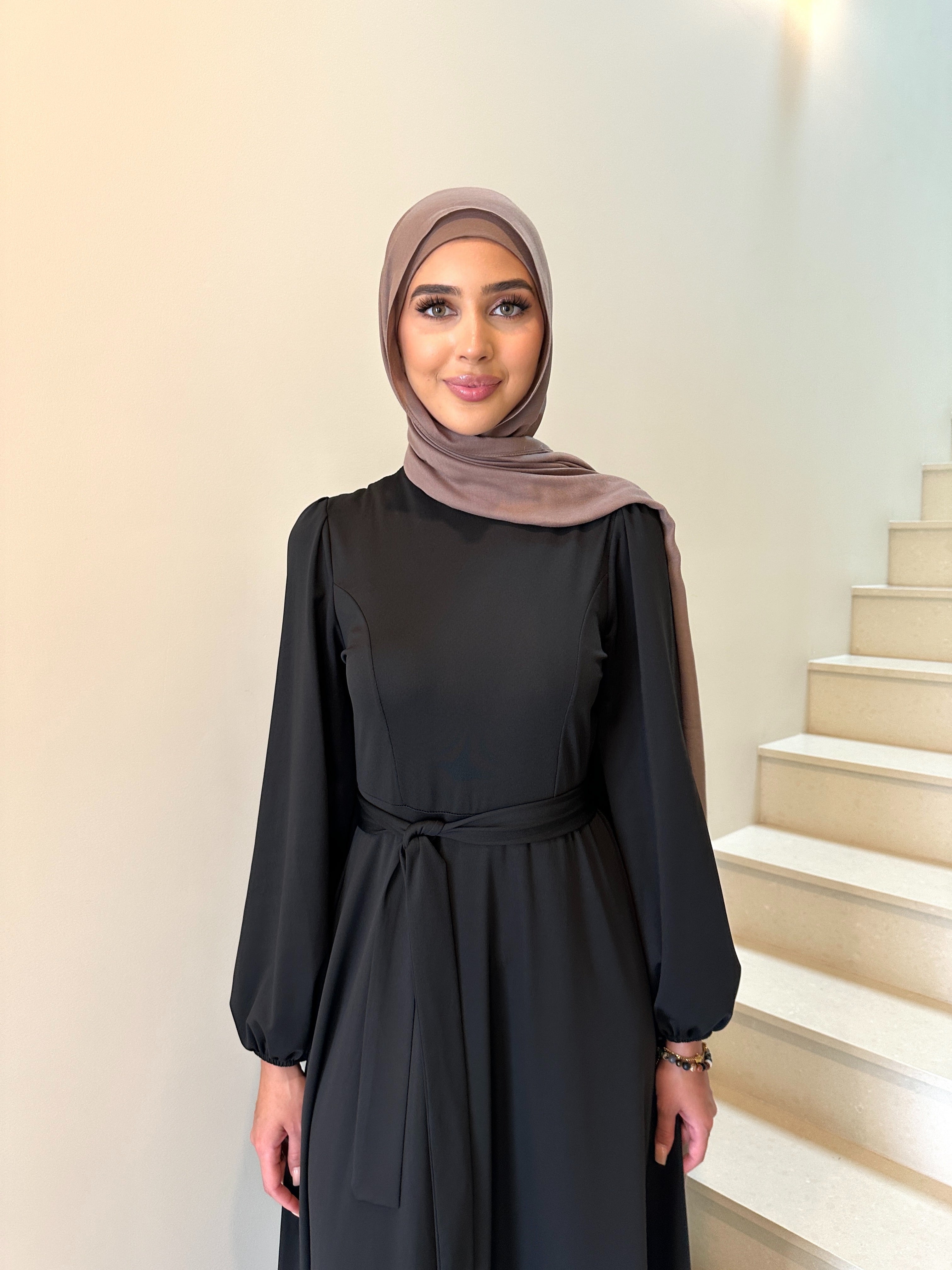 It has long sleeves and a fitted bodice with limited stretch, then drops from an empire cut waist to a loose high low skirt.