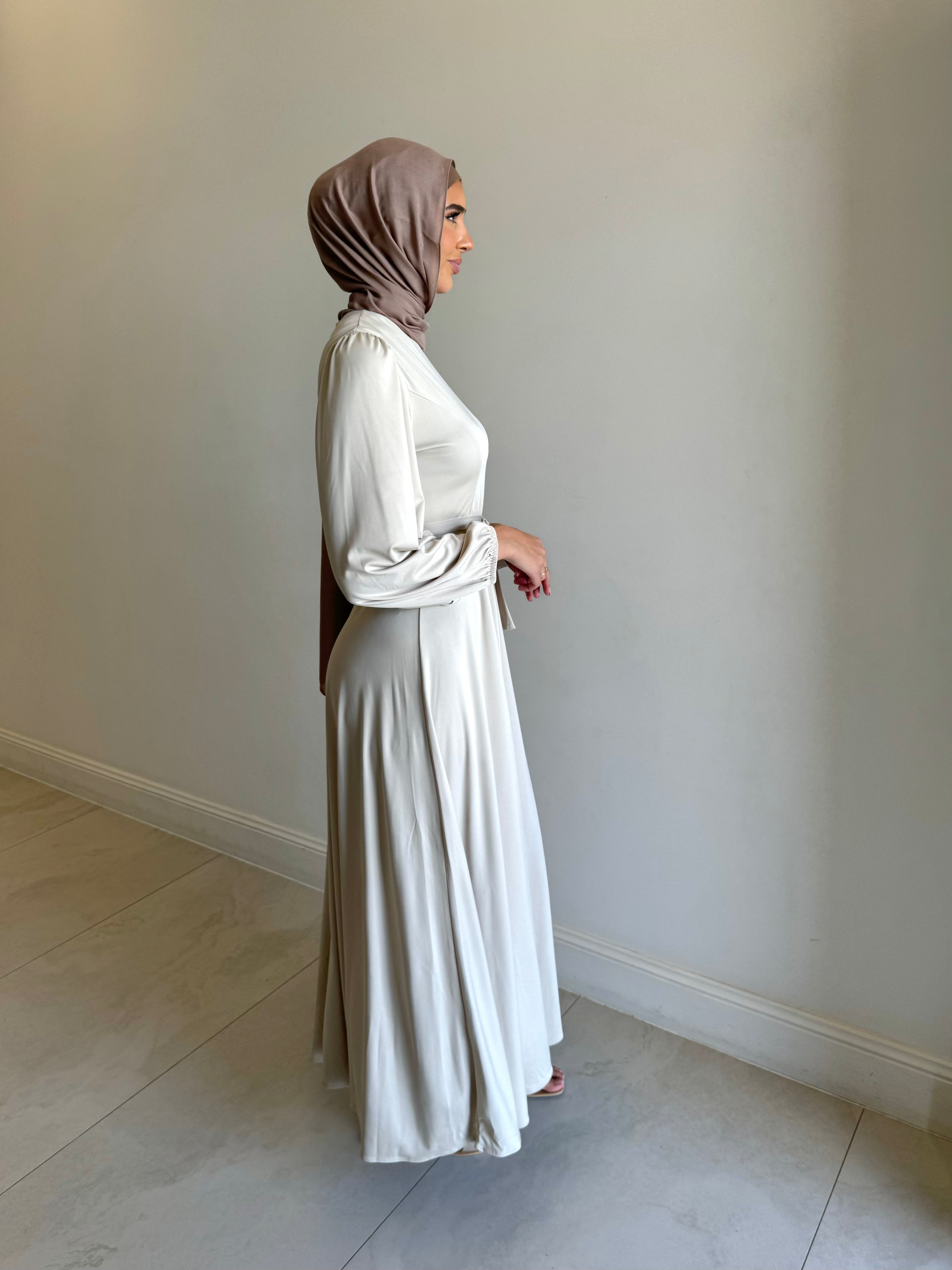 It has long sleeves and a fitted bodice with limited stretch, then drops from an empire cut waist to a loose high low skirt.