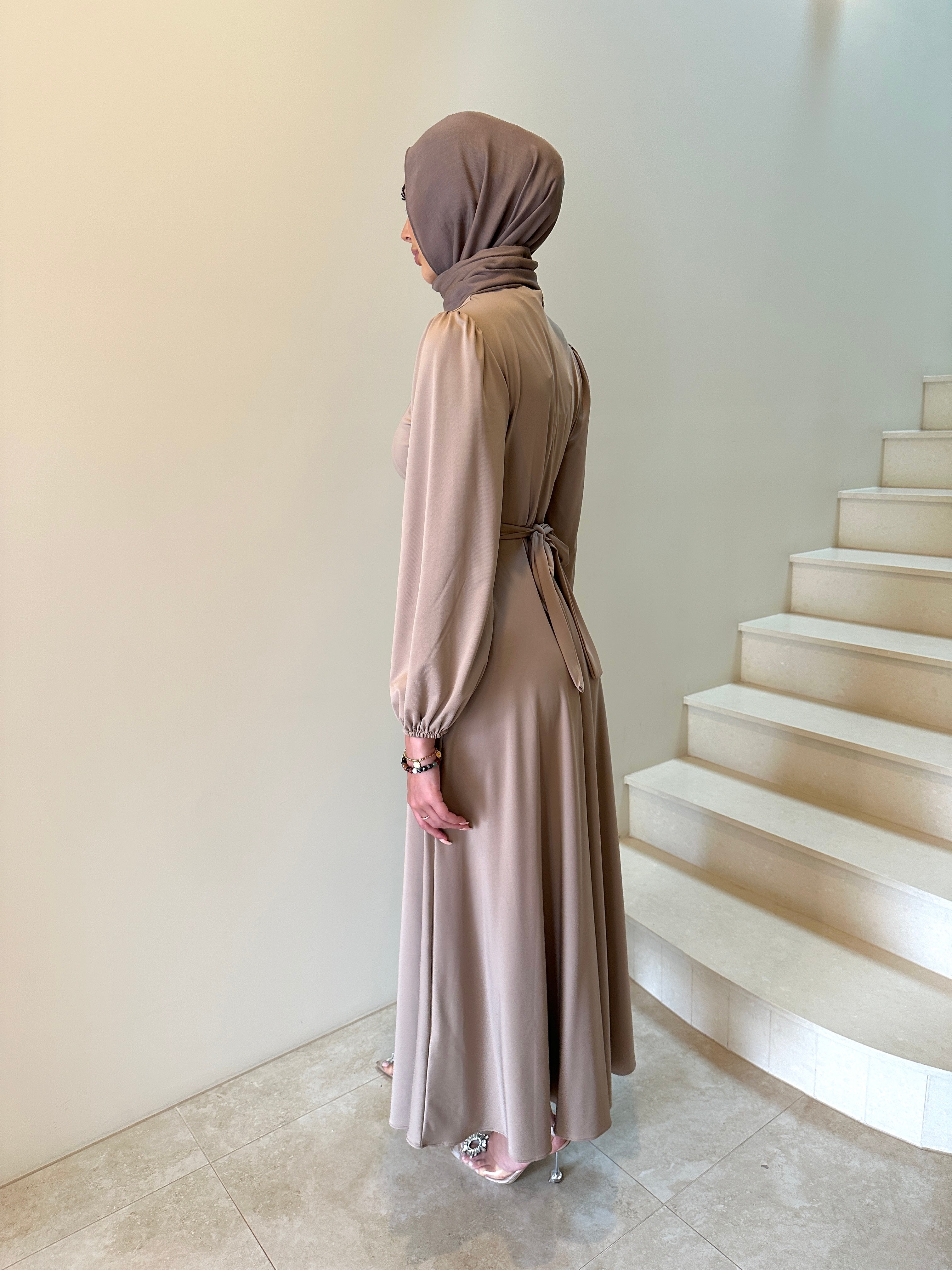 It has long sleeves and a fitted bodice with limited stretch, then drops from an empire cut waist to a loose high low skirt.