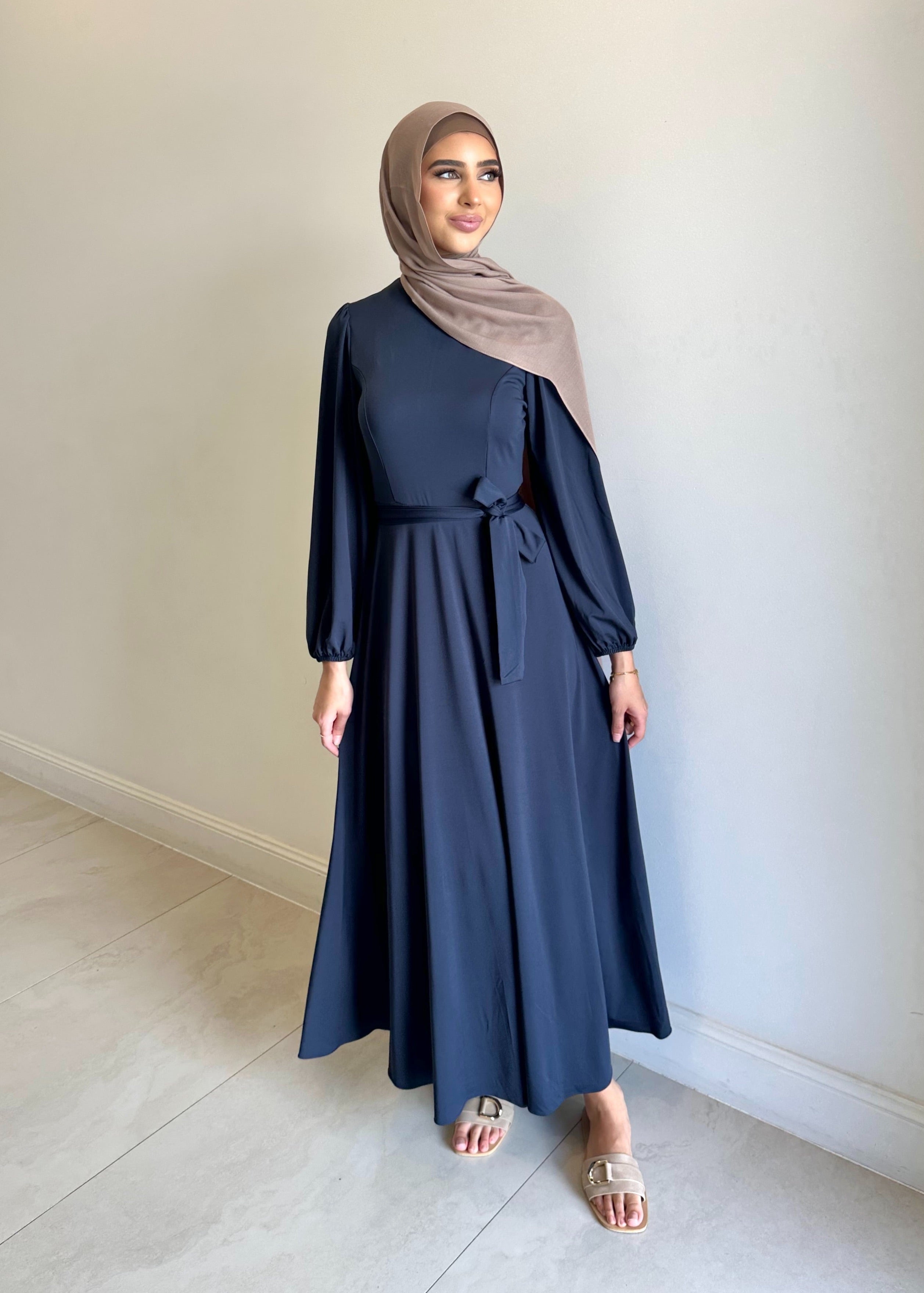 It has long sleeves and a fitted bodice with limited stretch, then drops from an empire cut waist to a loose high low skirt.