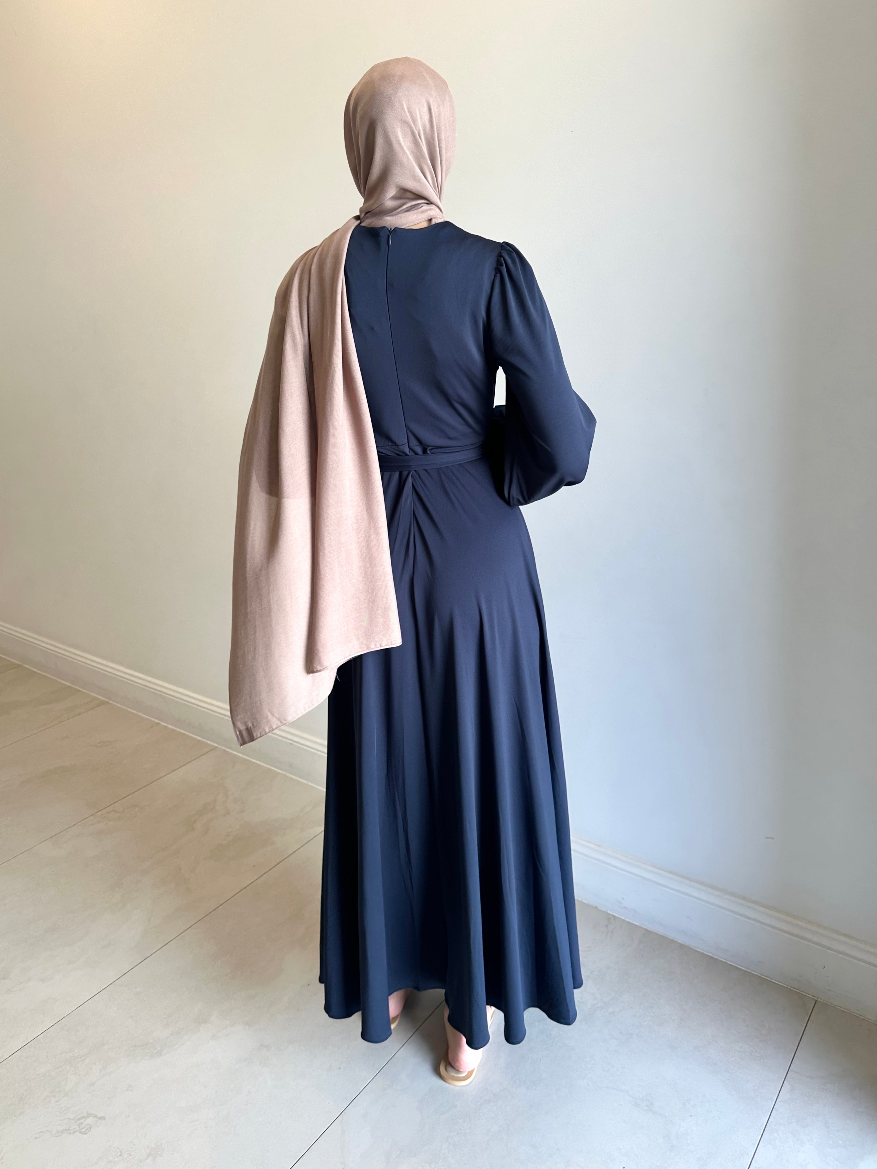 It has long sleeves and a fitted bodice with limited stretch, then drops from an empire cut waist to a loose high low skirt.