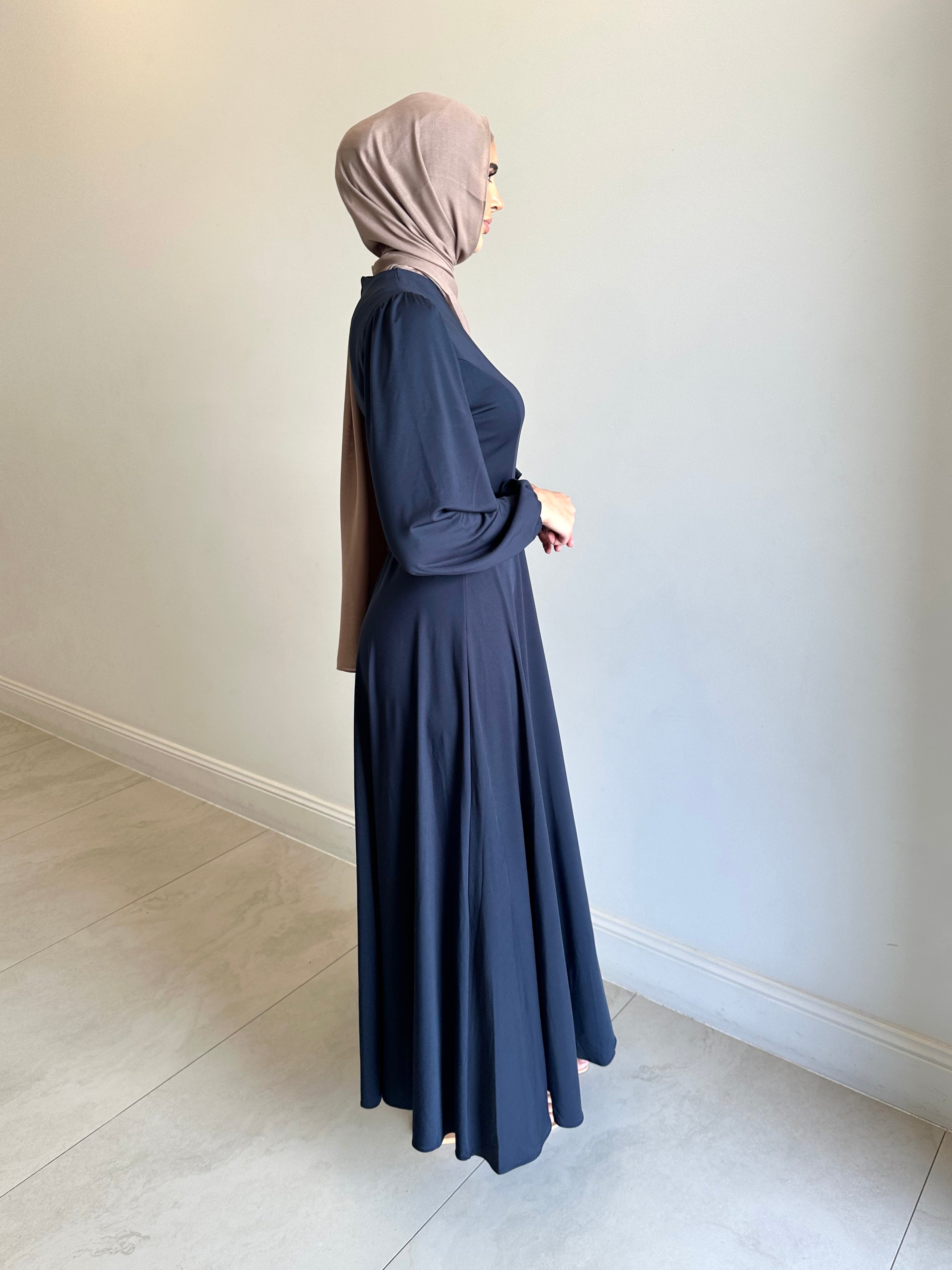It has long sleeves and a fitted bodice with limited stretch, then drops from an empire cut waist to a loose high low skirt.