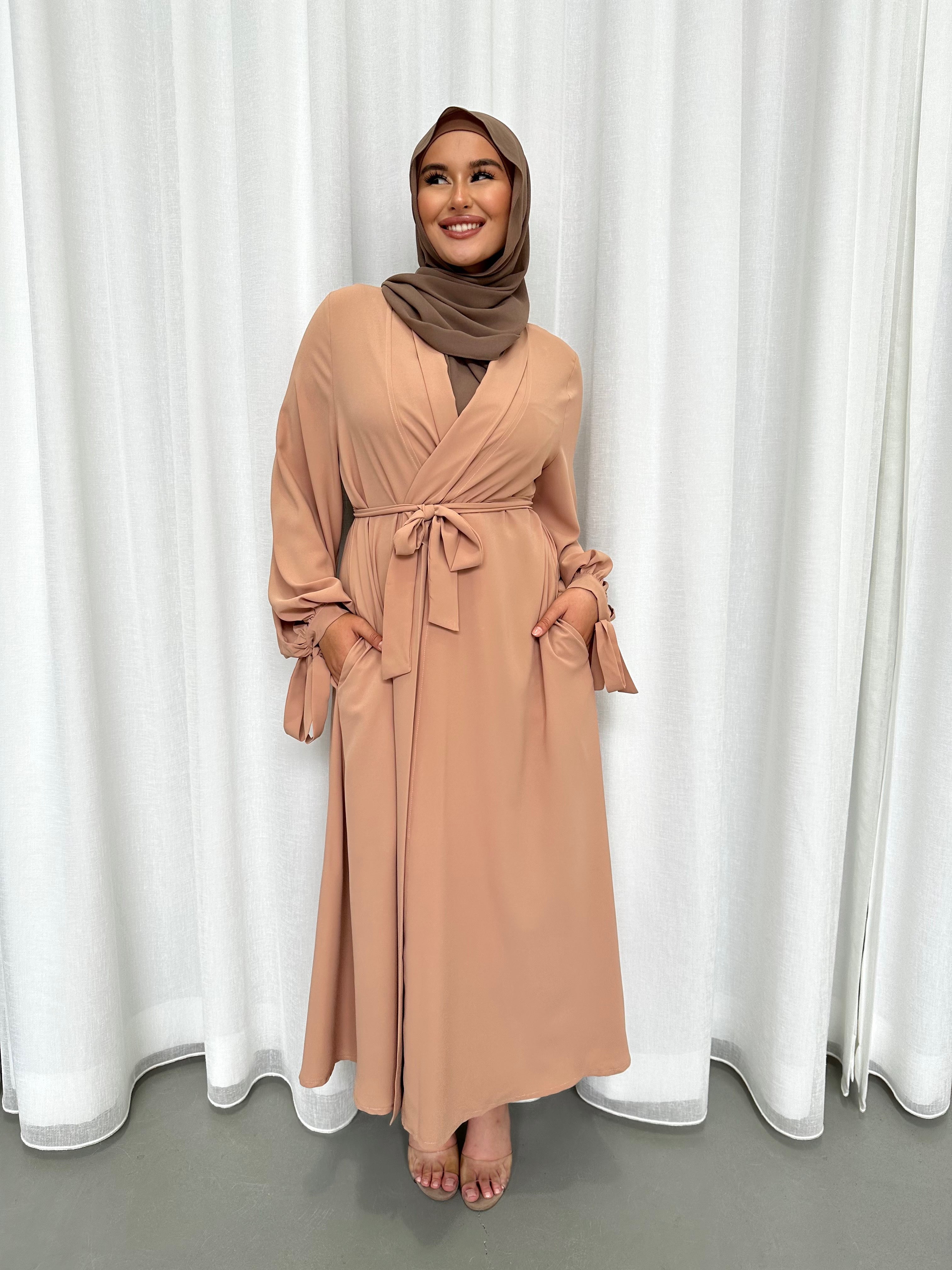 It's made from polyester, designed for a loose fit on the body and has long balloon sleeves with shirred tie cuffs then drops to a floor length.