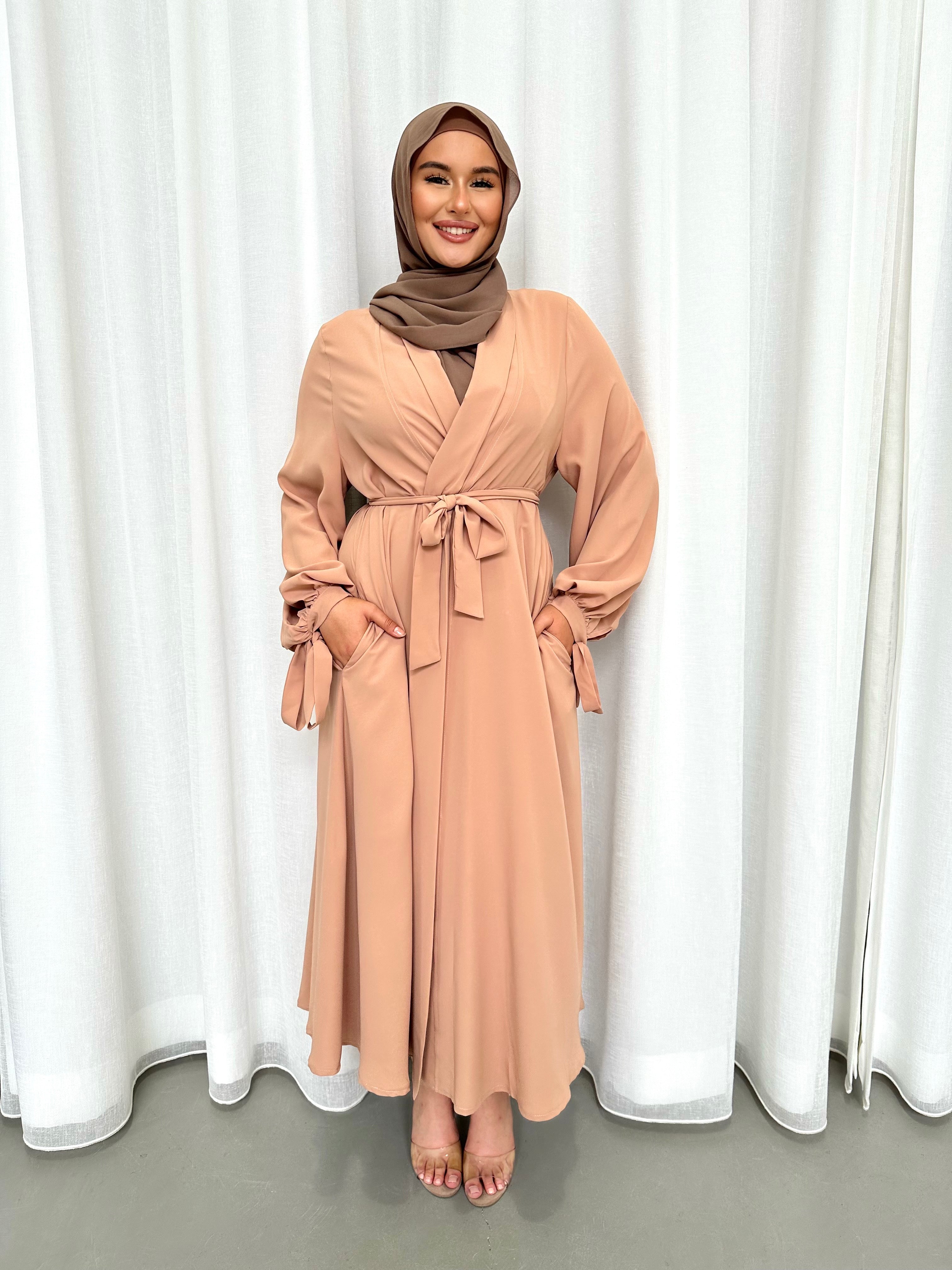 It's made from polyester, designed for a loose fit on the body and has long balloon sleeves with shirred tie cuffs then drops to a floor length.